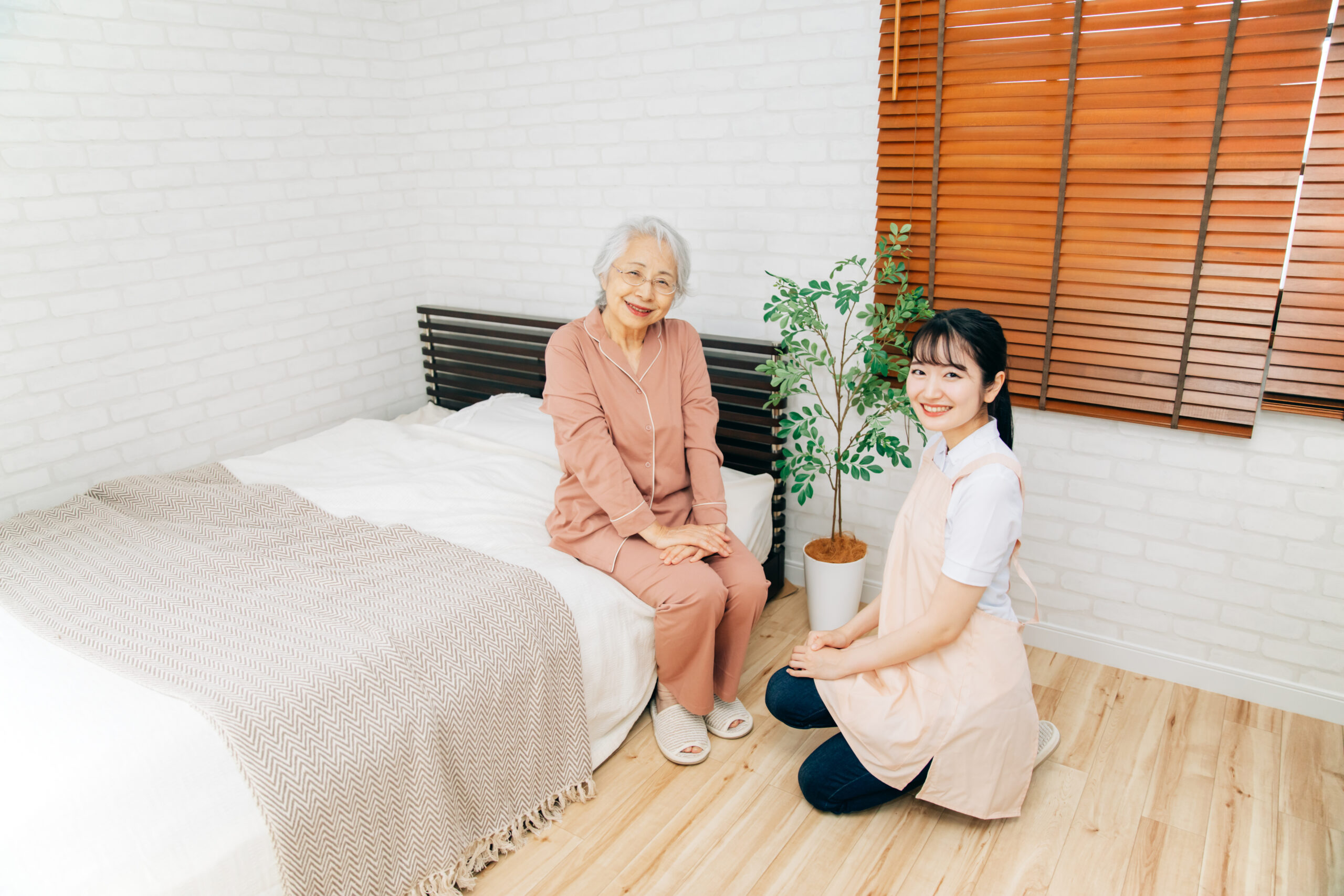 寝室にいる高齢者女性と介護する女性