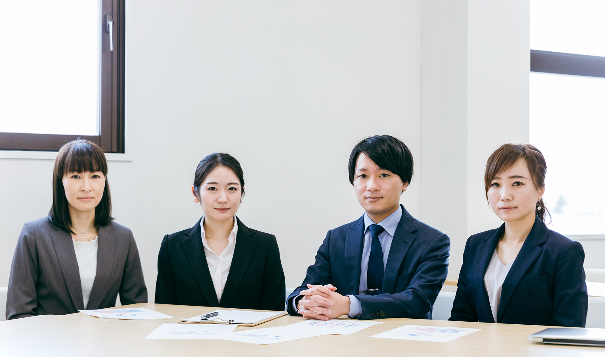 オフィスのテーブルに座る男女の会社員