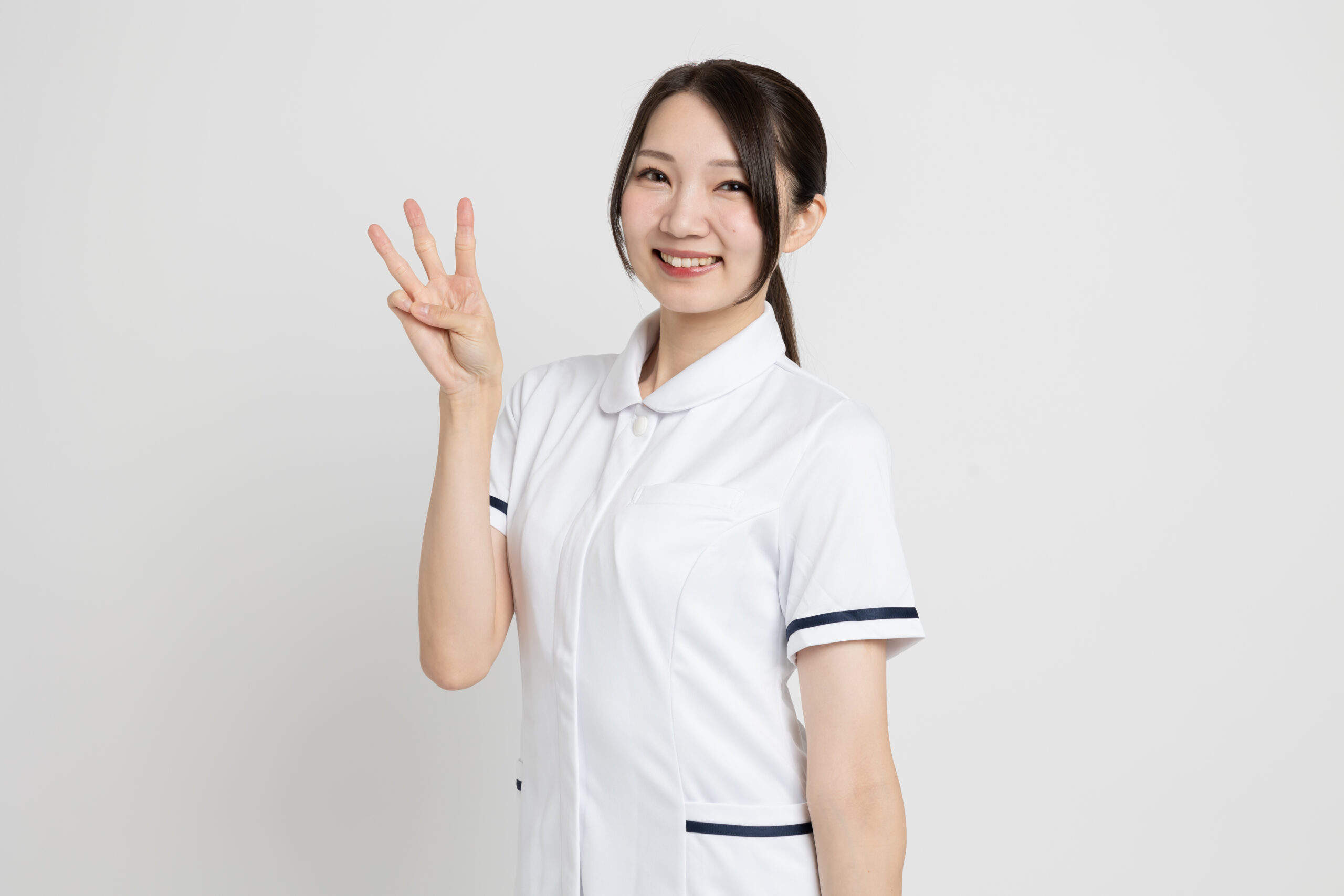 3本指を立てる看護師