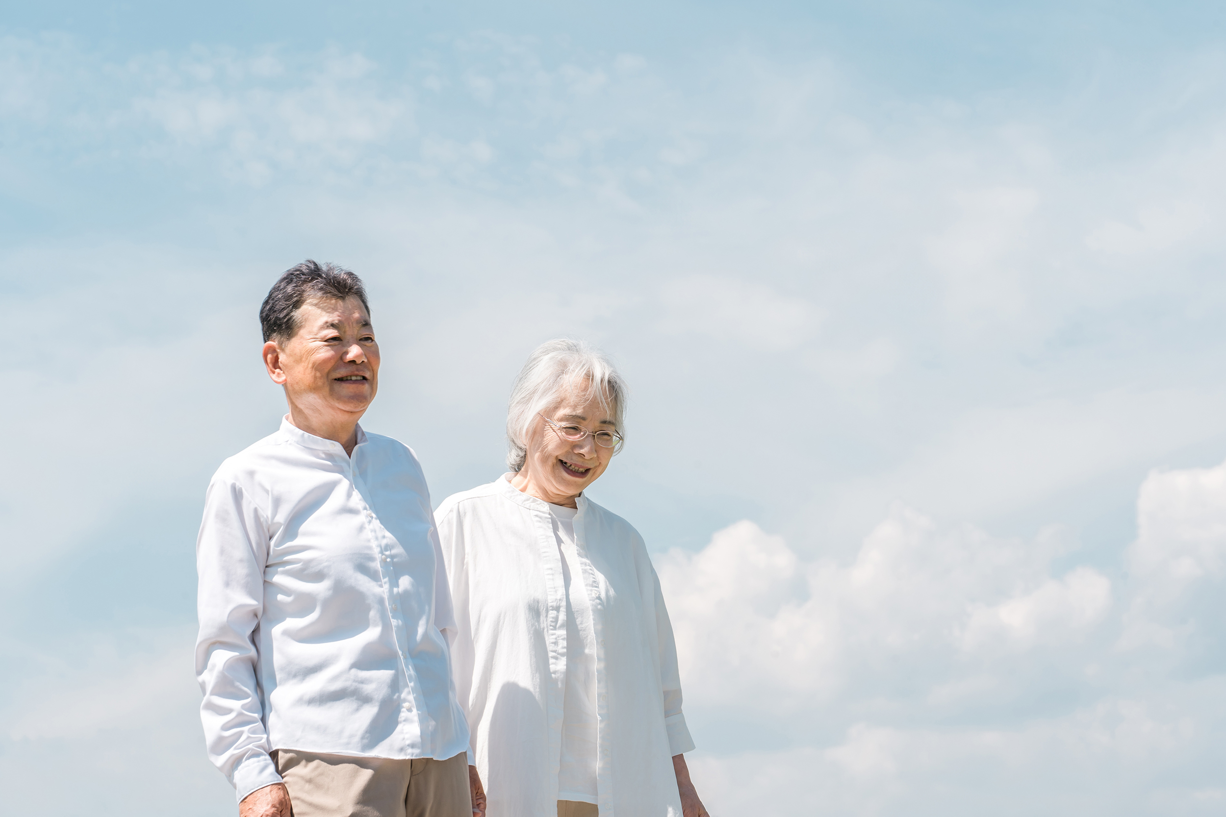 公園・旅行先を話しながら歩く高齢者夫婦
