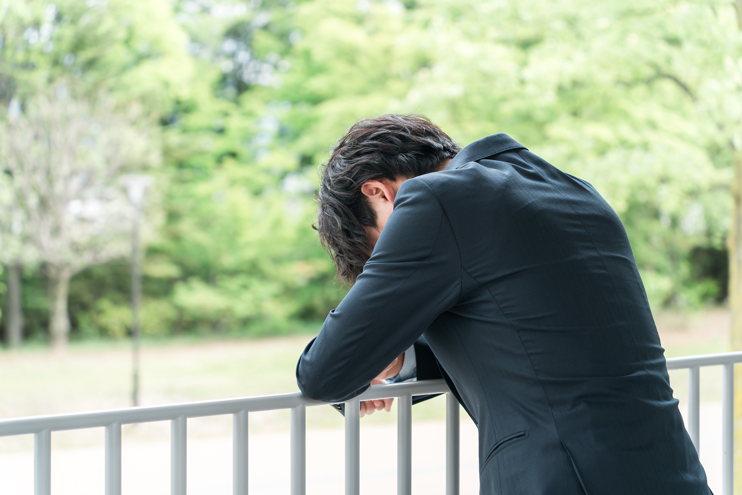 新緑の中にいる若いスーツ姿のビジネスマン