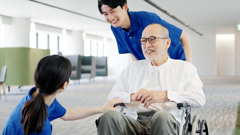 介護士と話をする車椅子の高齢者