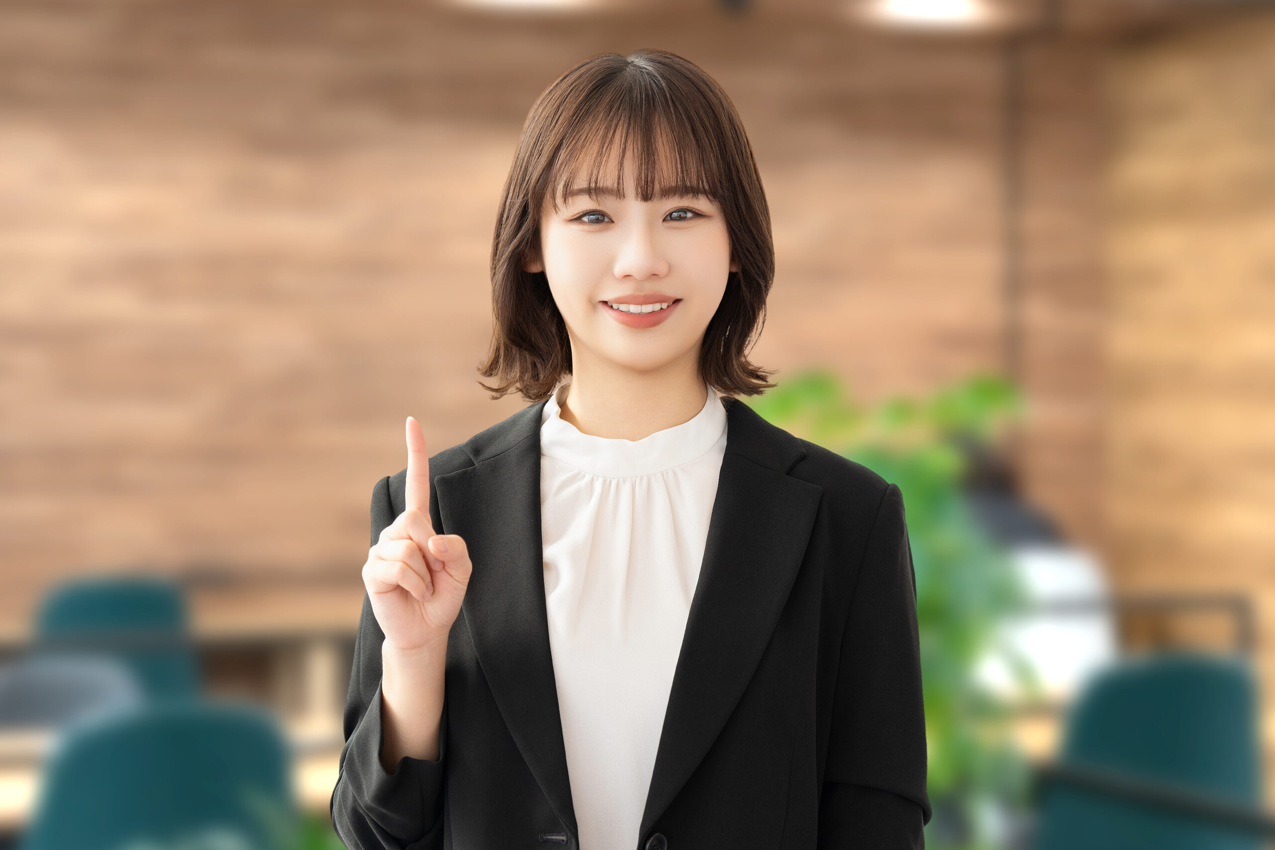 人差し指を立てて案内する笑顔の女性