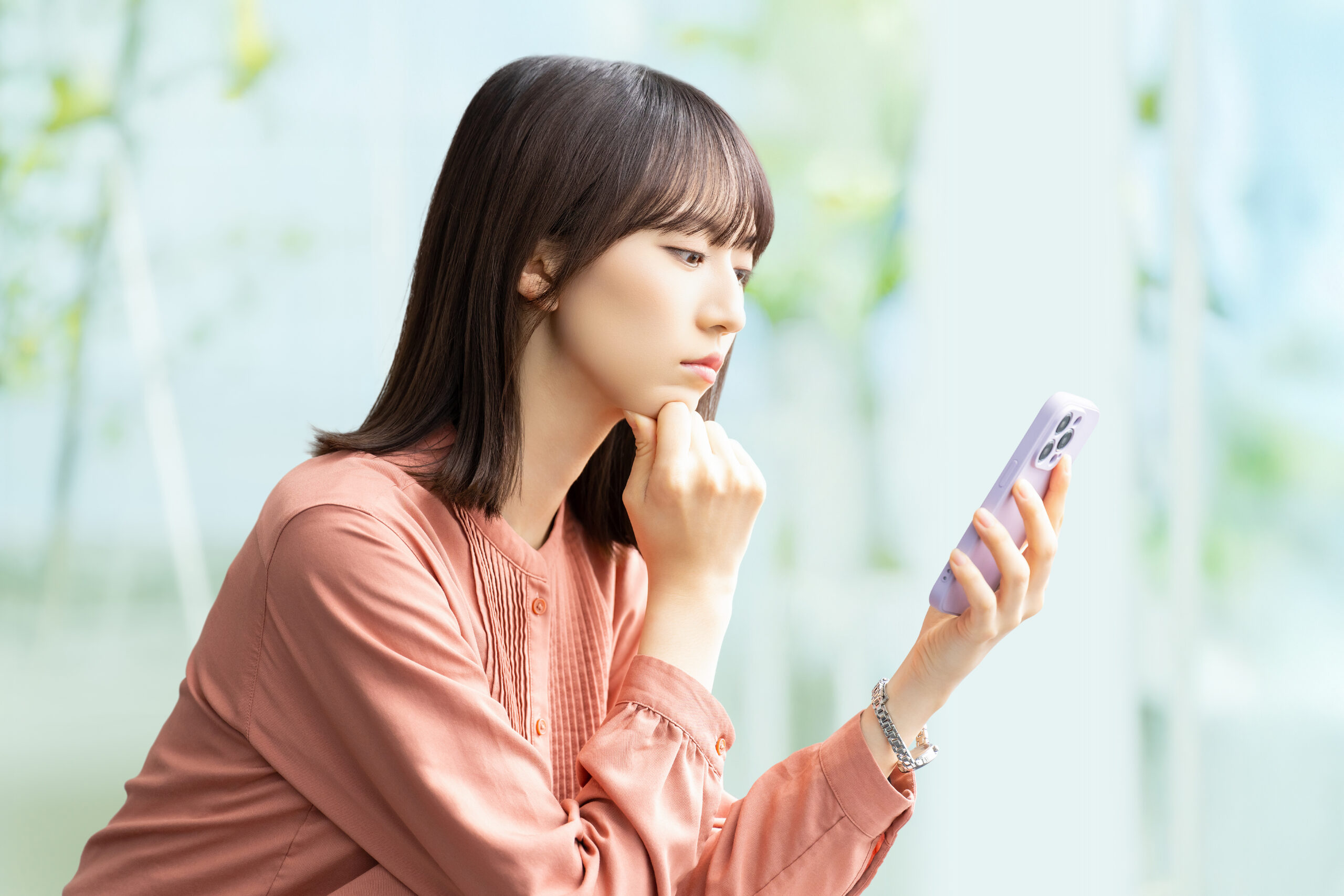 スマホを見て考える女性・ビジネスウーマン