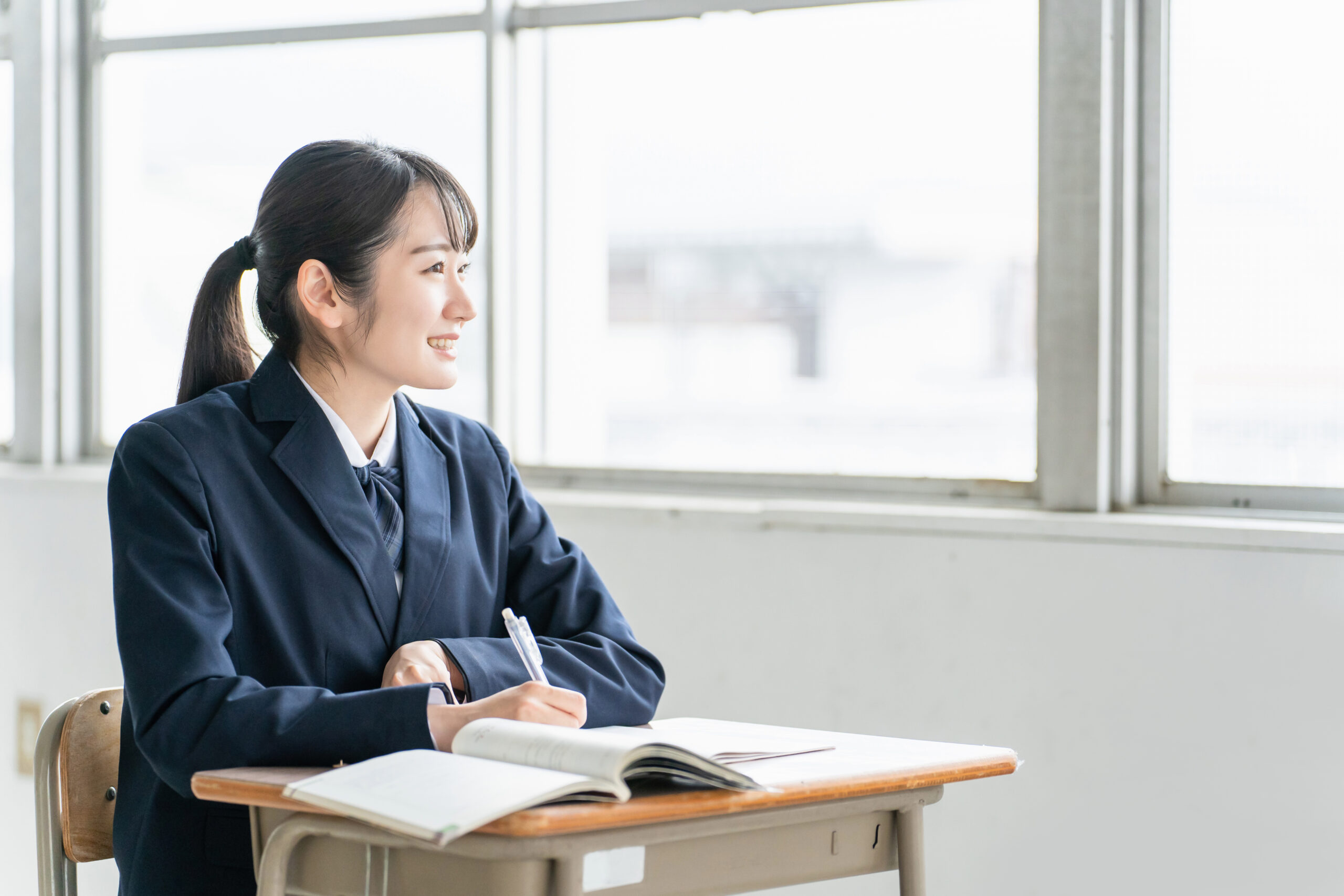 参考書を見ながら勉強する女子高校生