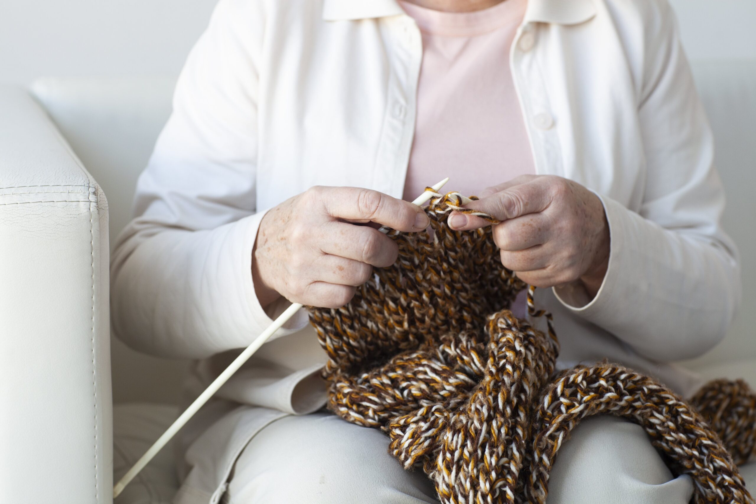 ソファで編み物をするおばあさん