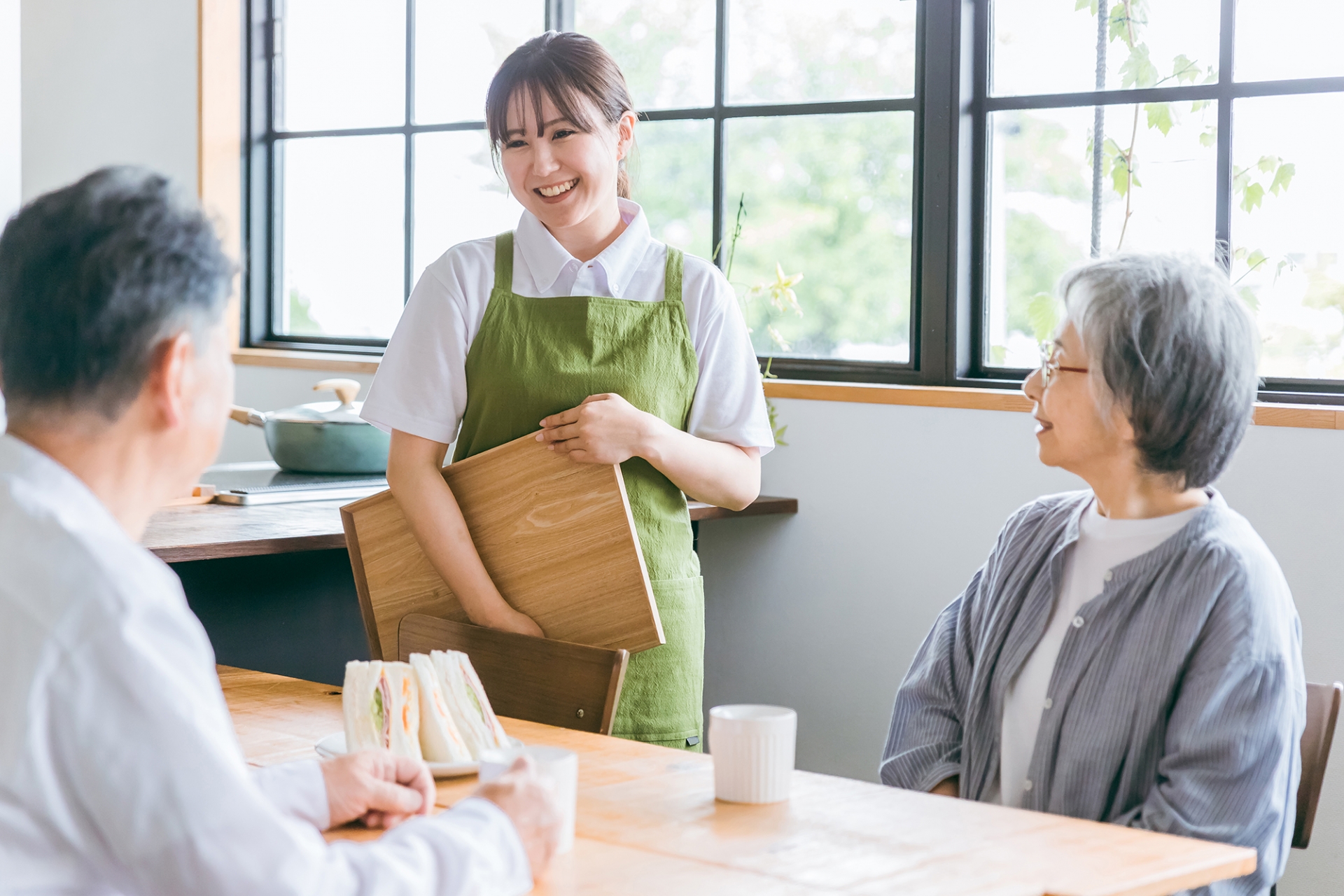高齢夫婦と話す女性