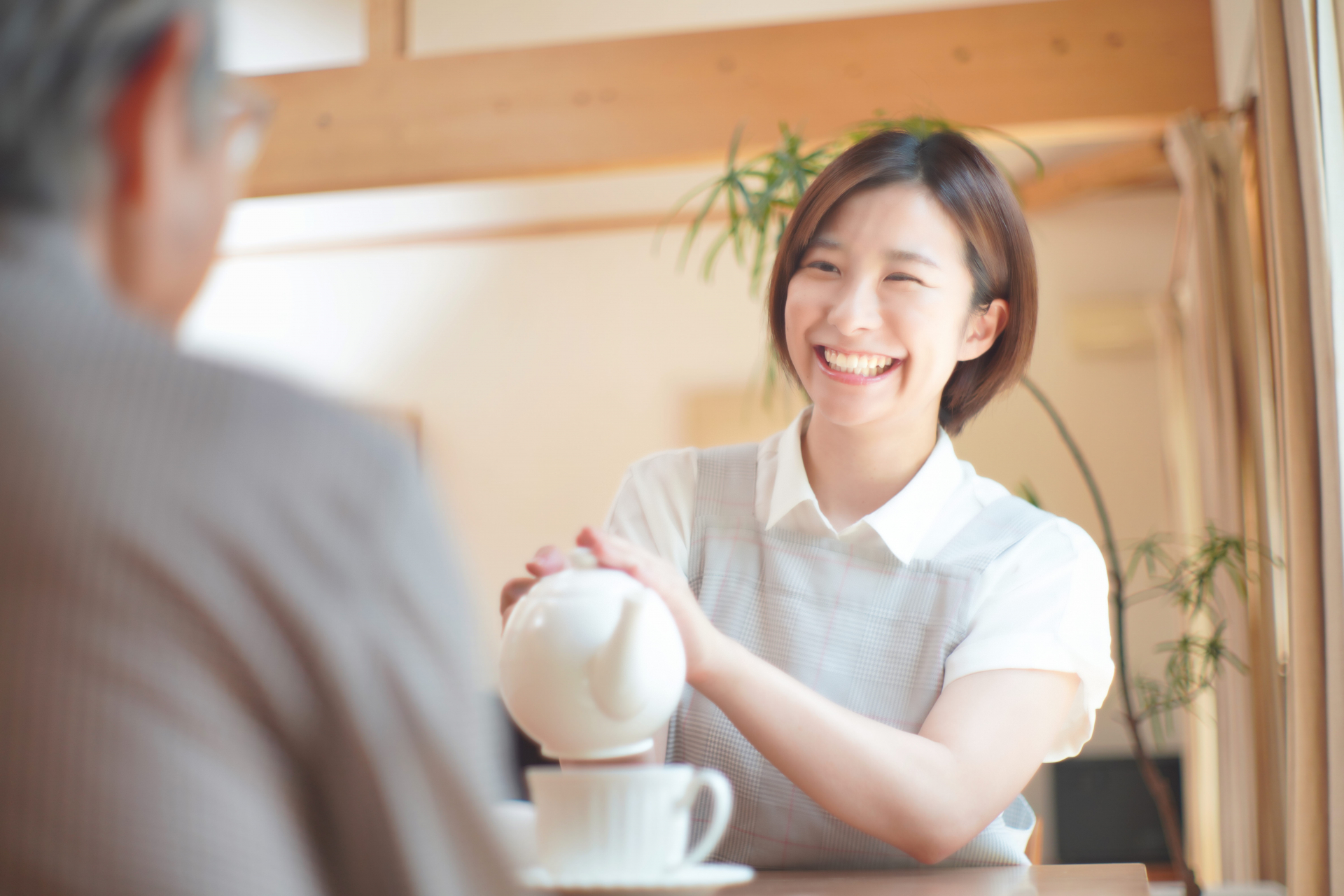 お茶を淹れる笑顔の女性