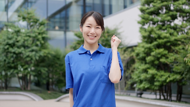 ガッツポーズをする青い服の女性