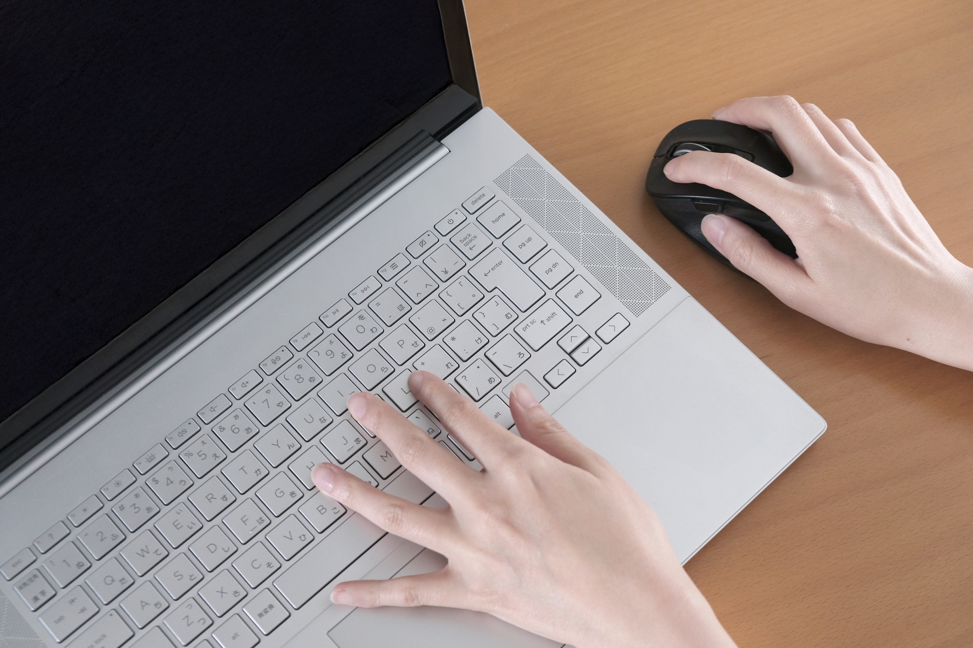 ノートパソコンで作業する女性の手元