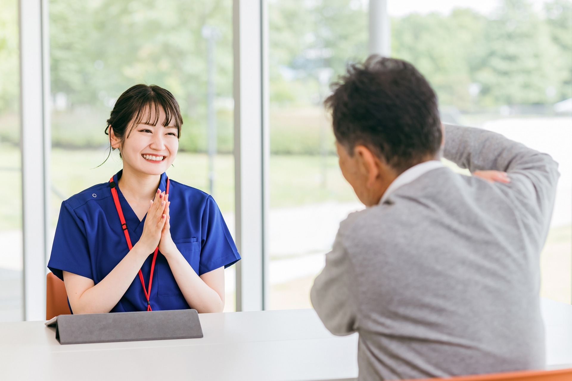 男性患者と会話する看護師の女性