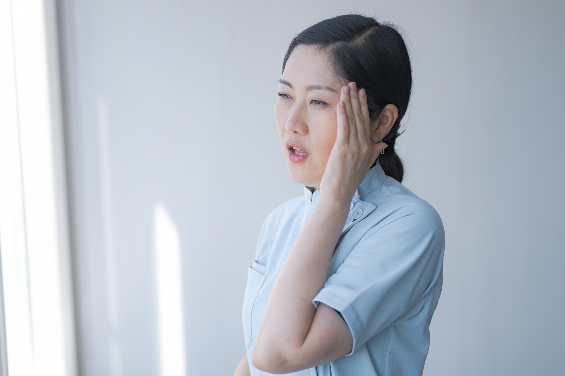 頭に手をやる女性