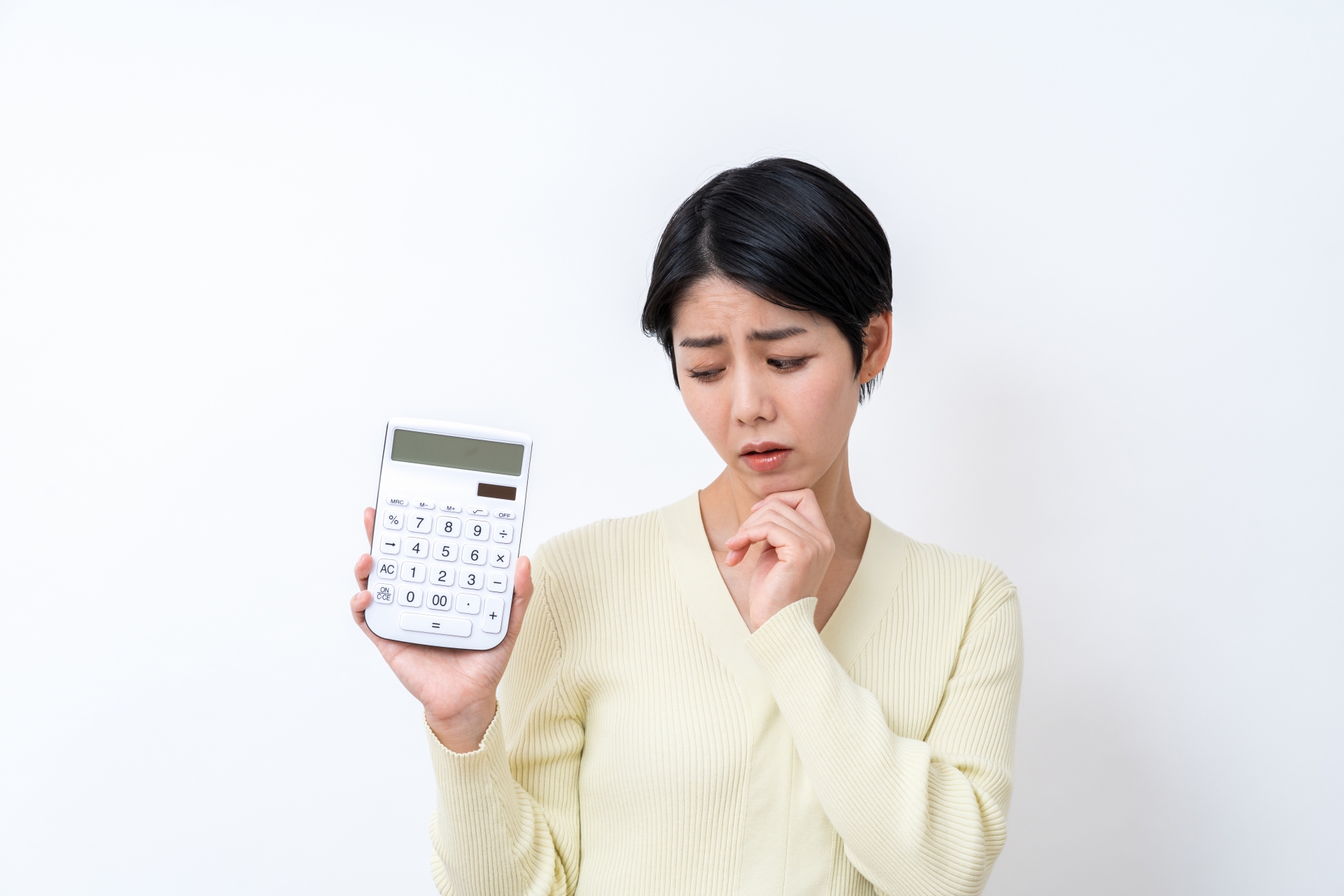 電卓を持って悩む女性