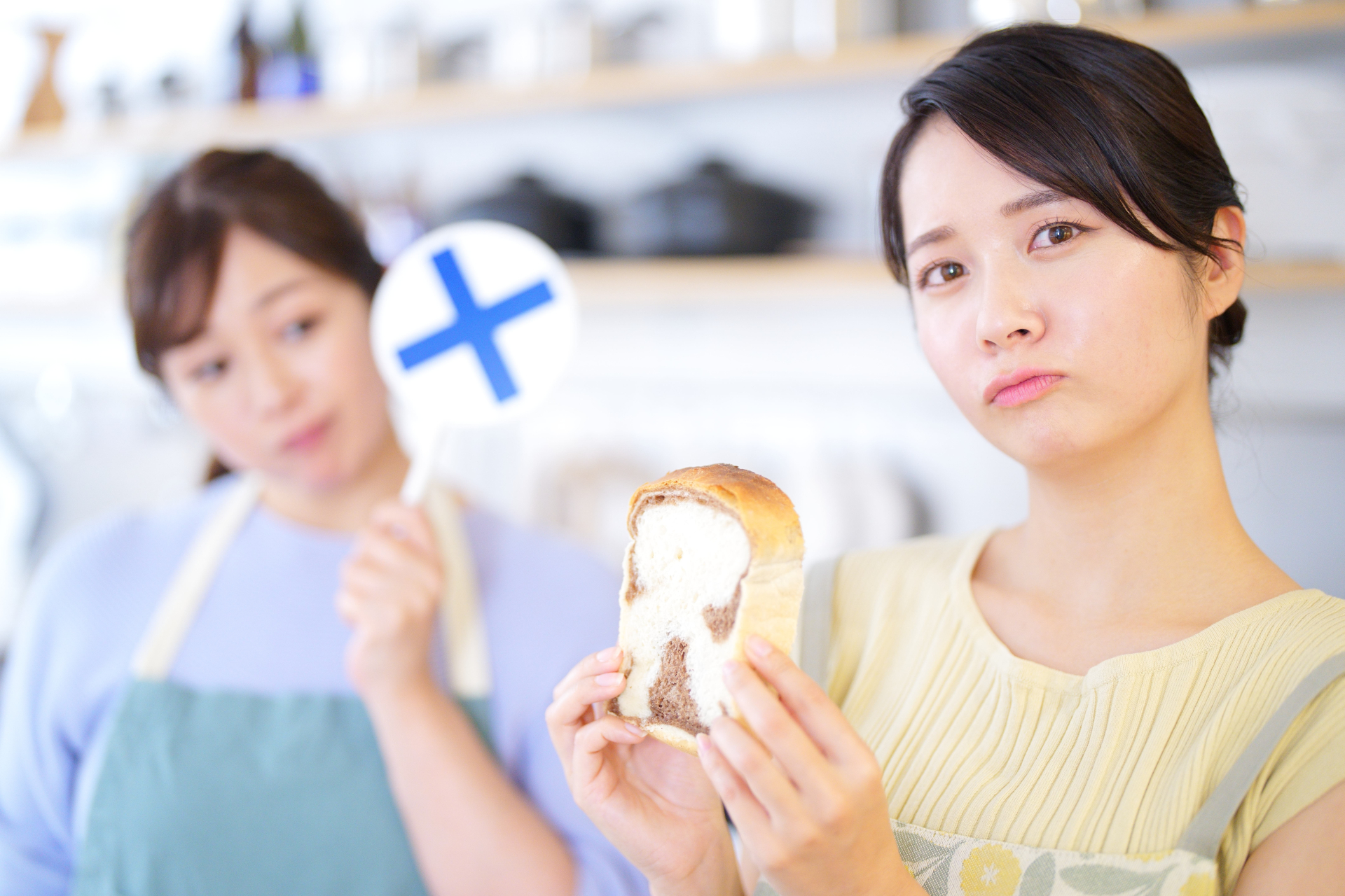 食パンを持ち不機嫌な女性とバツプレート