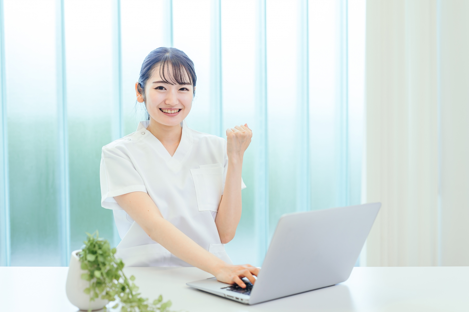 パソコンの前でガッツポーズをする女性