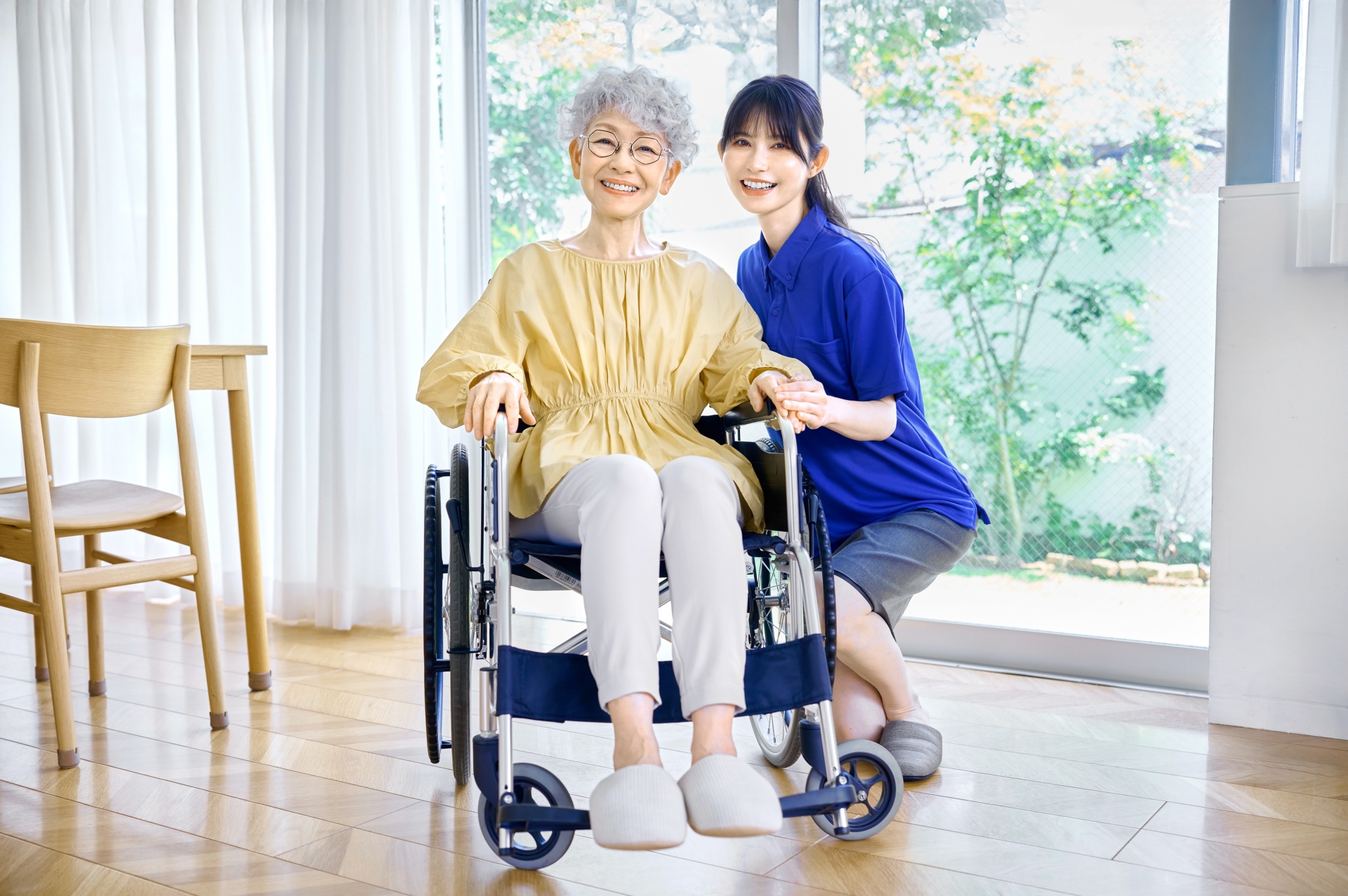 笑顔の車椅子の女性と介護士