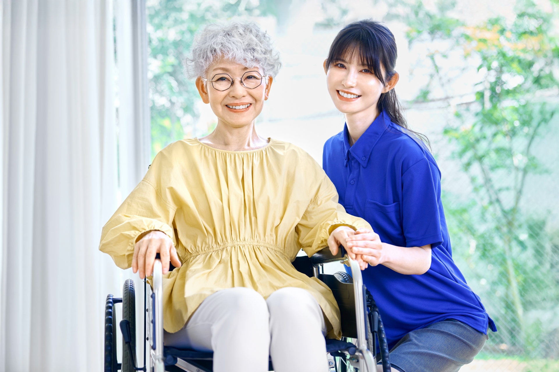 笑顔の車椅子の女性と介護士