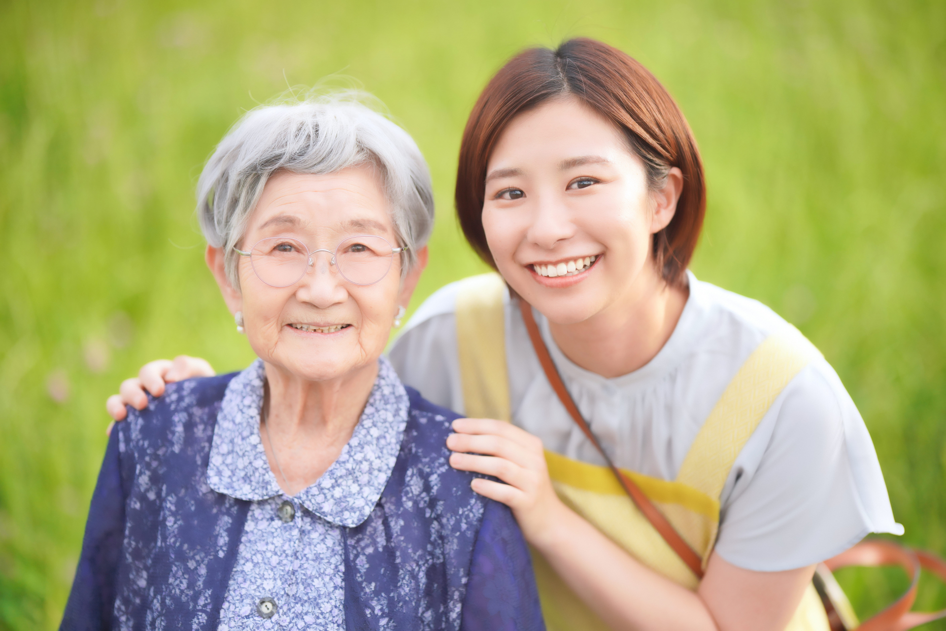 高齢女性の肩に手をおくエプロンの女性