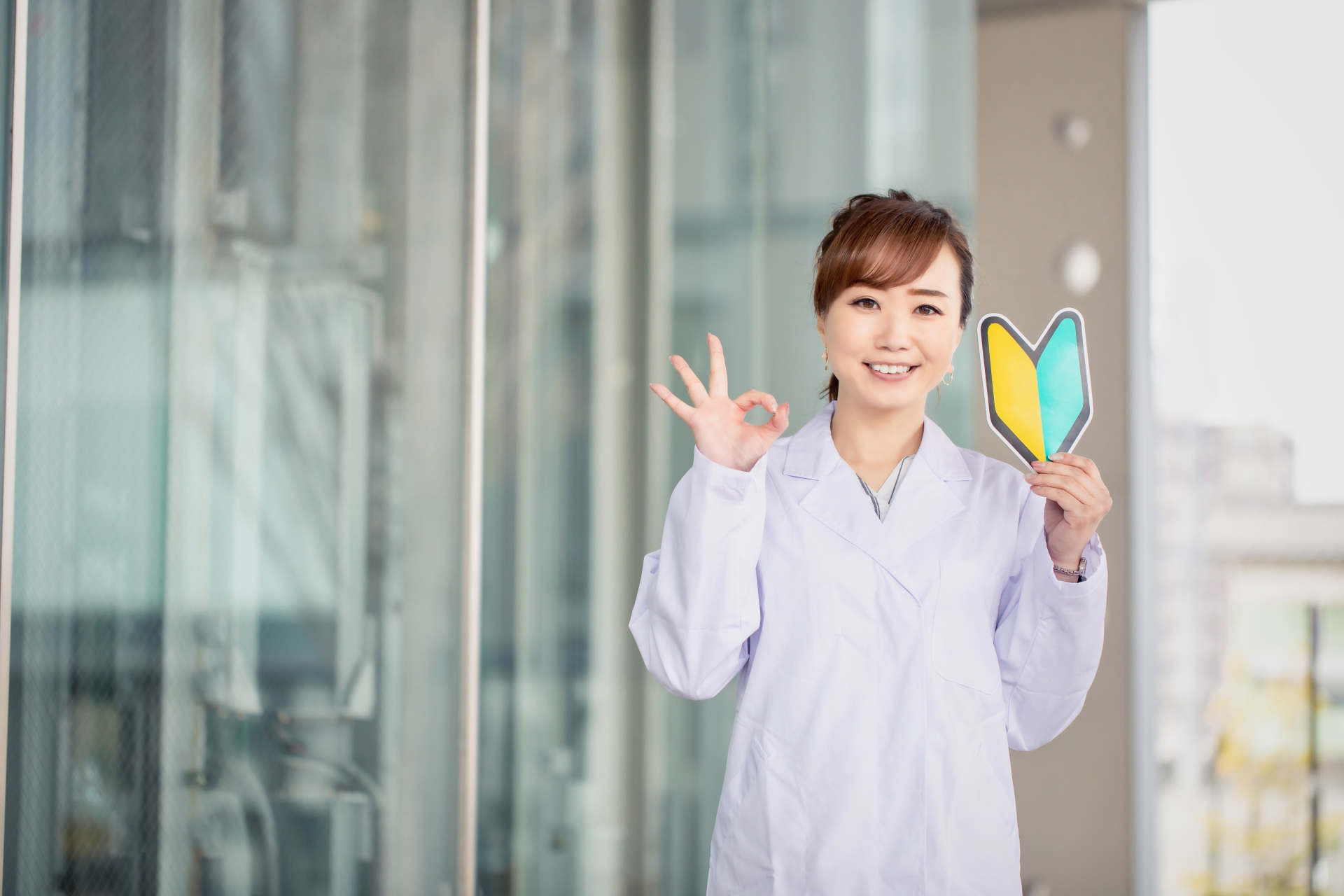 初心者マークを持った白衣の女性