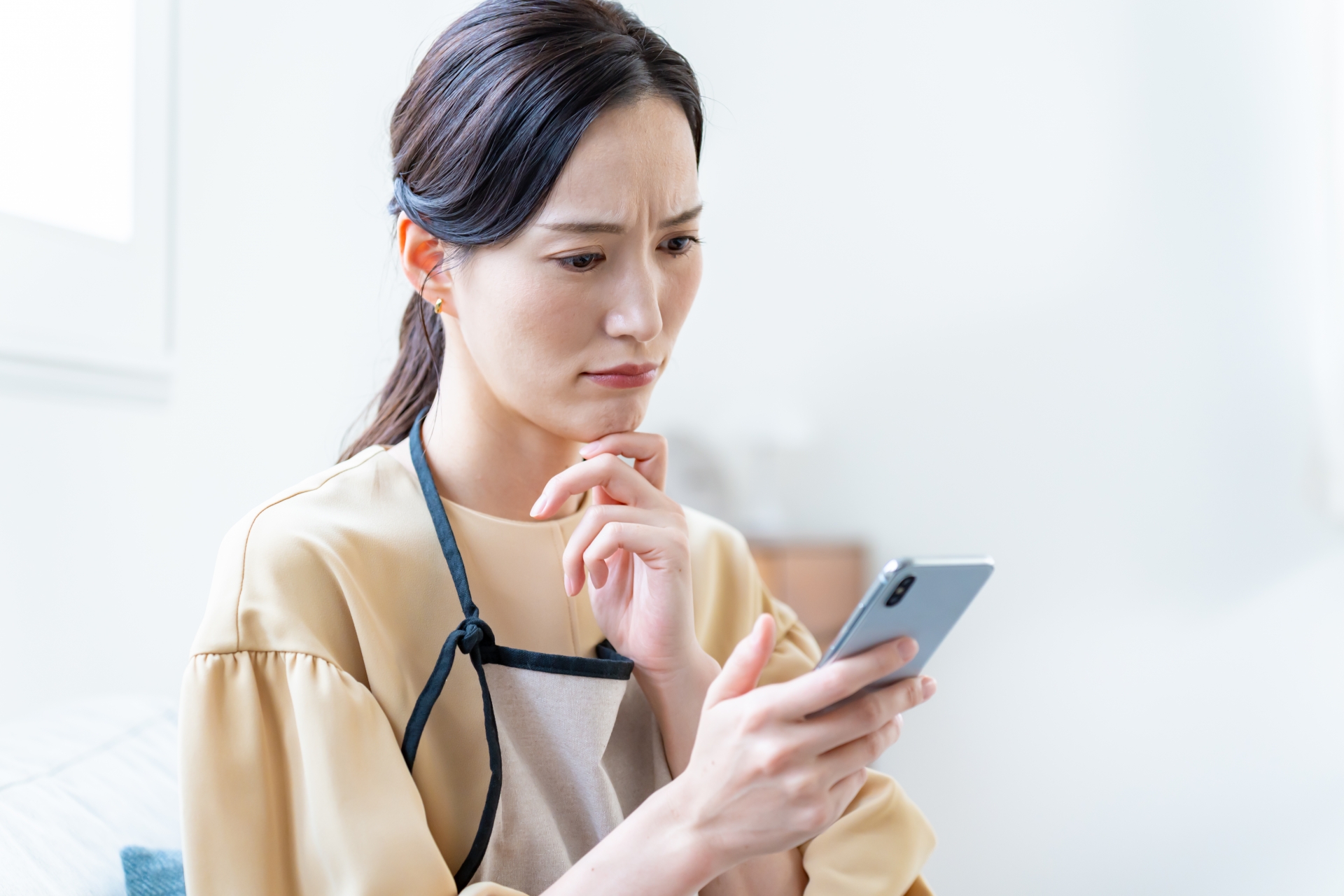 スマホを見て顔をしかめる女性