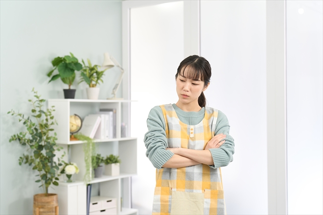 悩むエプロンを着た女性