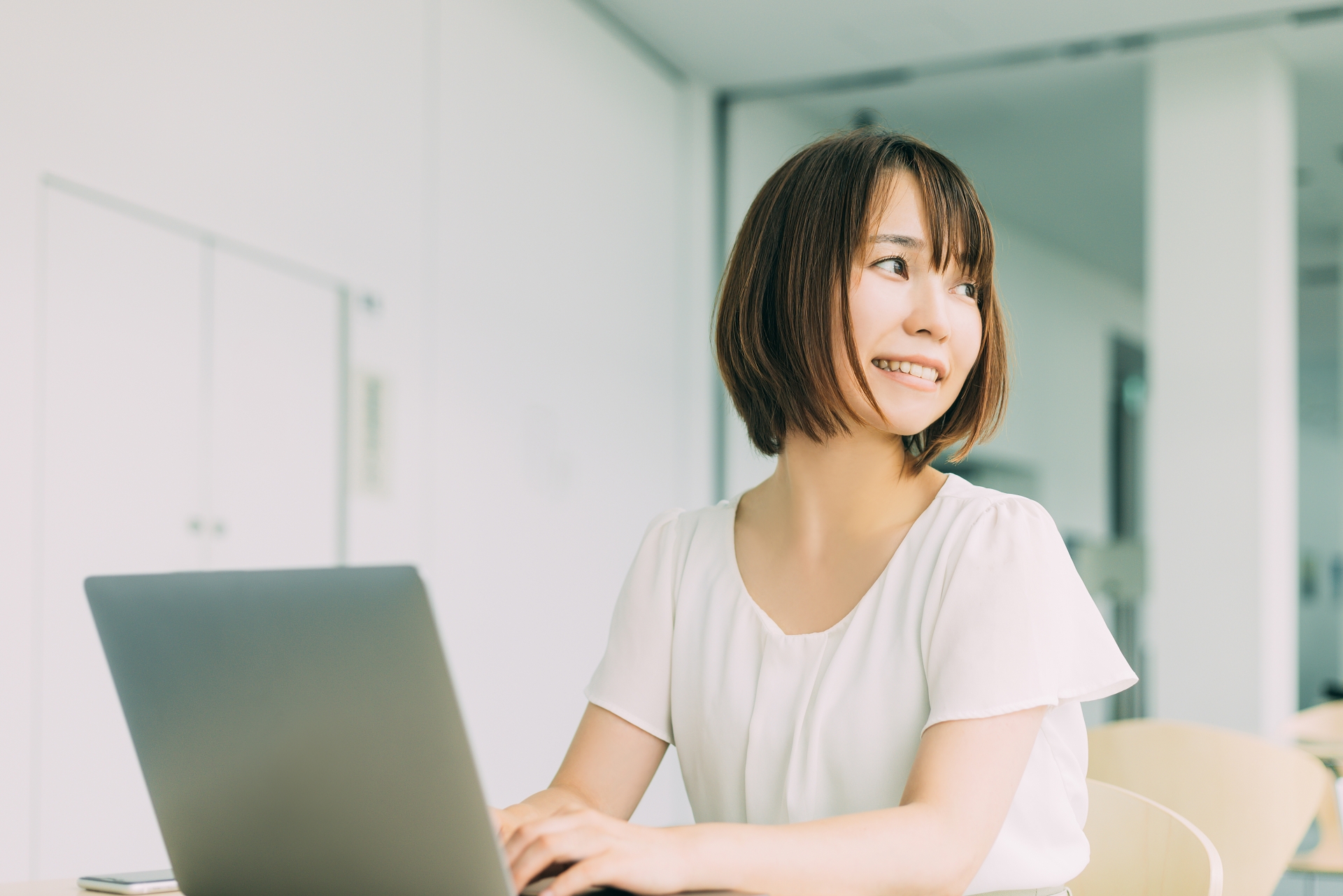 ノートパソコンを使う笑顔の日本人女性