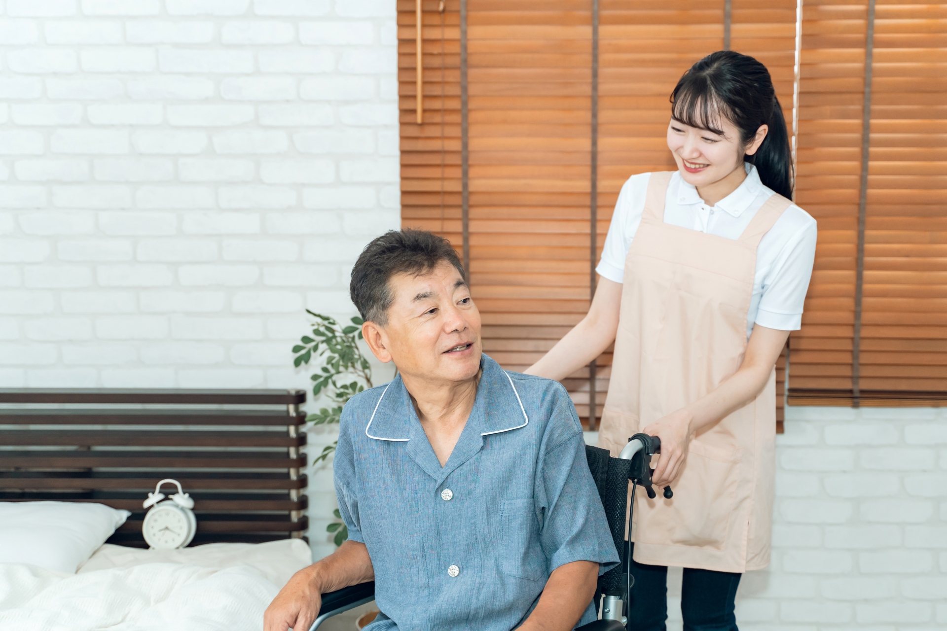 車椅子に座る高齢者男性と介護士