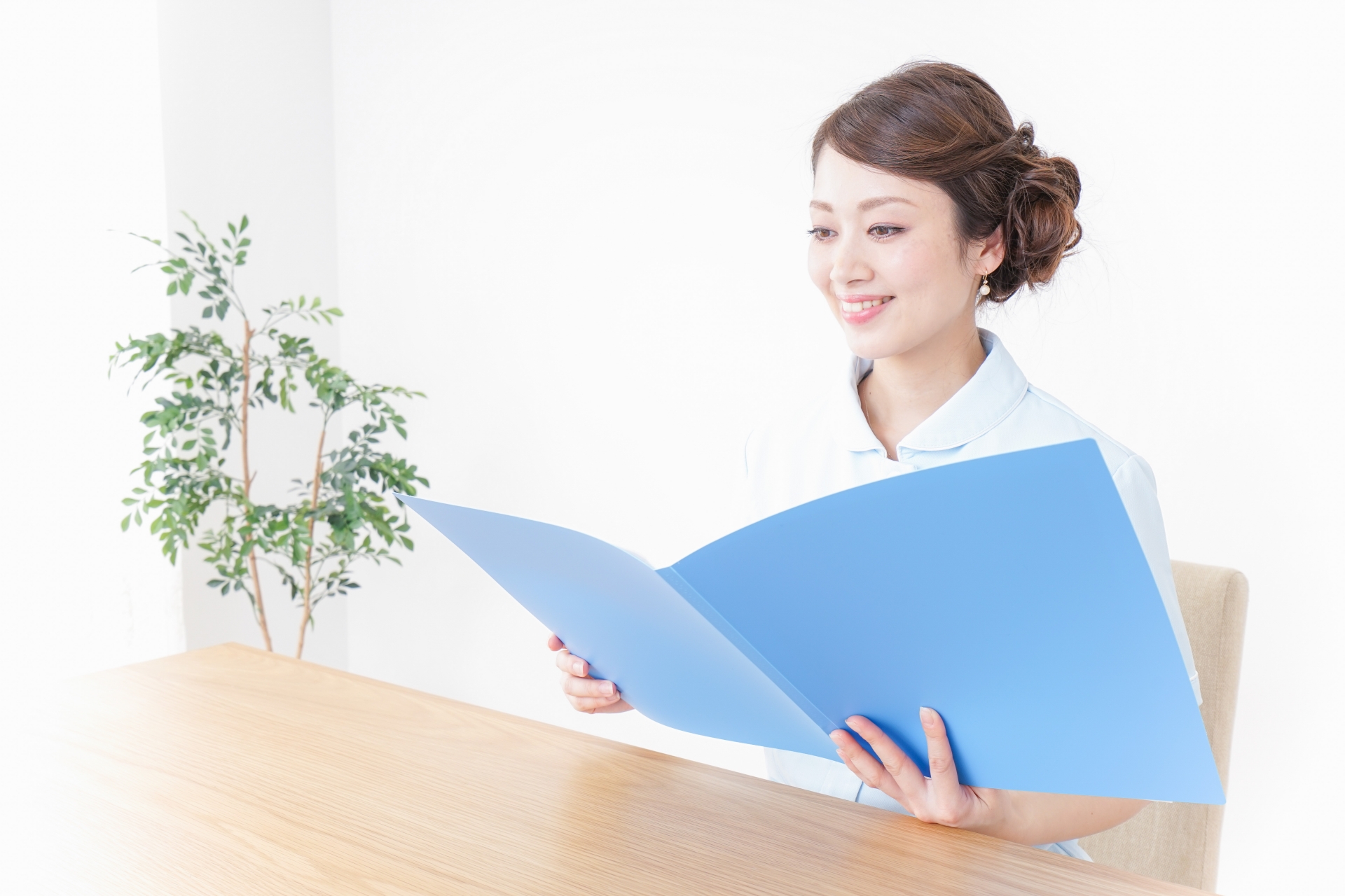 青いファイルを見る女性