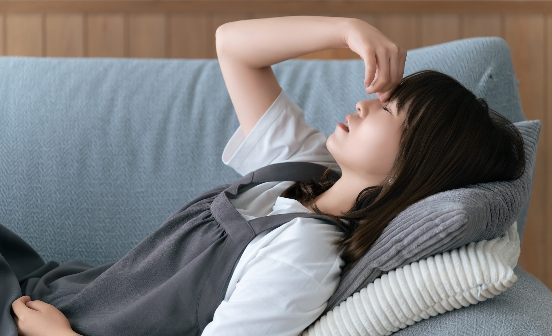 疲れてソファに寝転ぶ女性