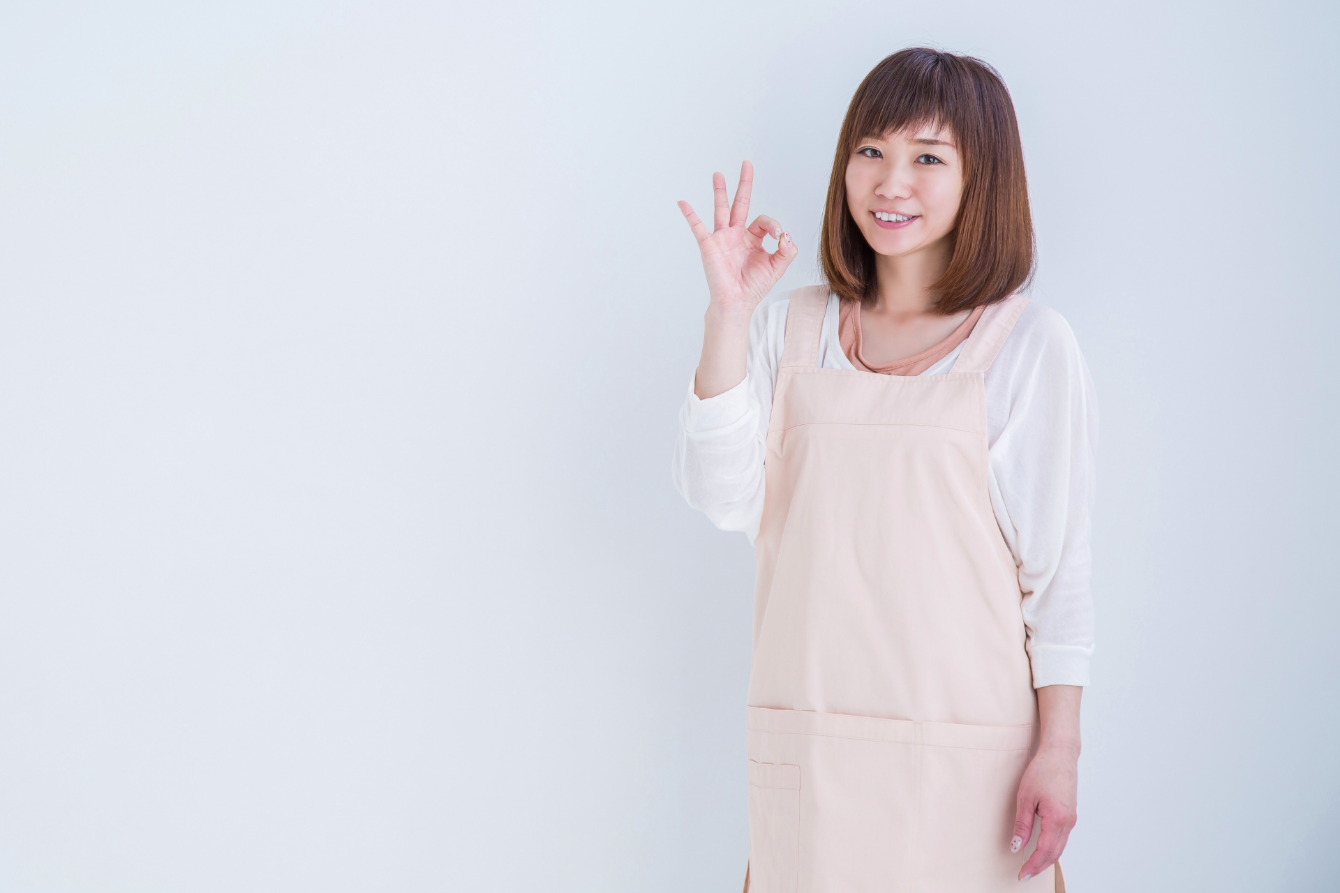 OKサインするエプロン姿の女性