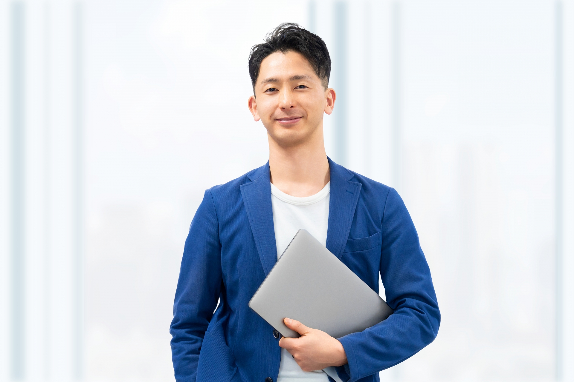 パソコンを持つ笑顔の男性ビジネスマン