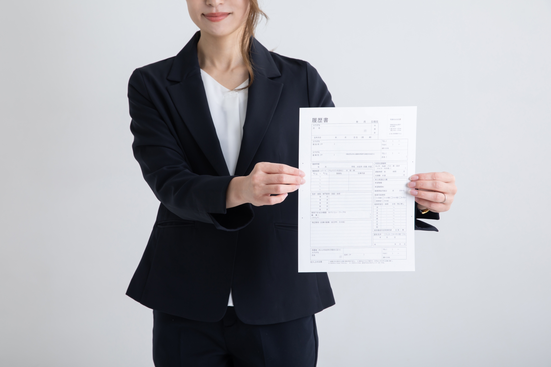 書類を手に持つスーツの女性