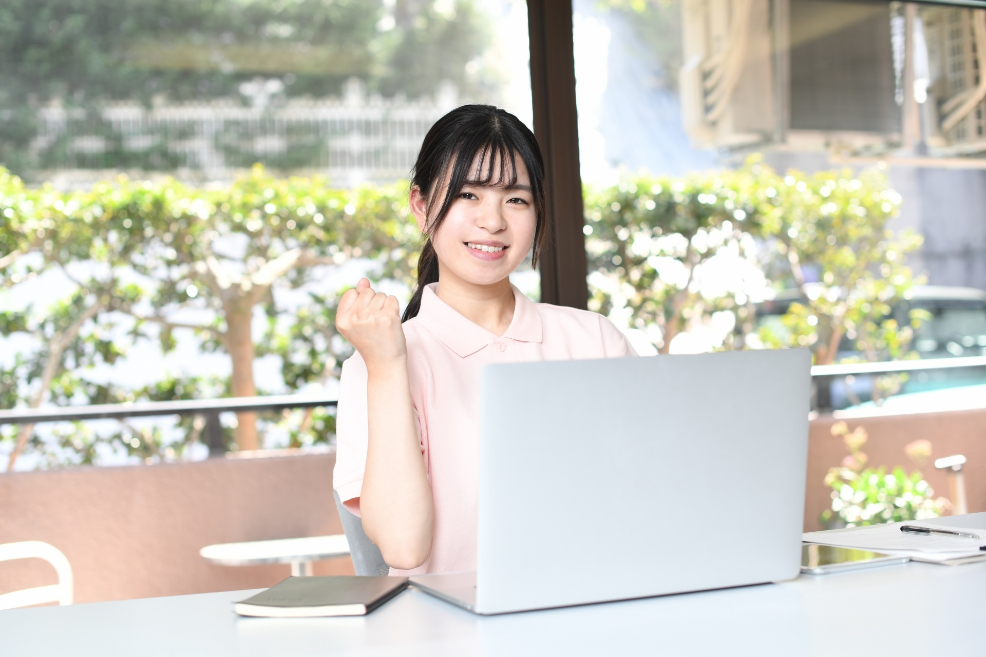 PCで事務作業をする笑顔のアジア人女性