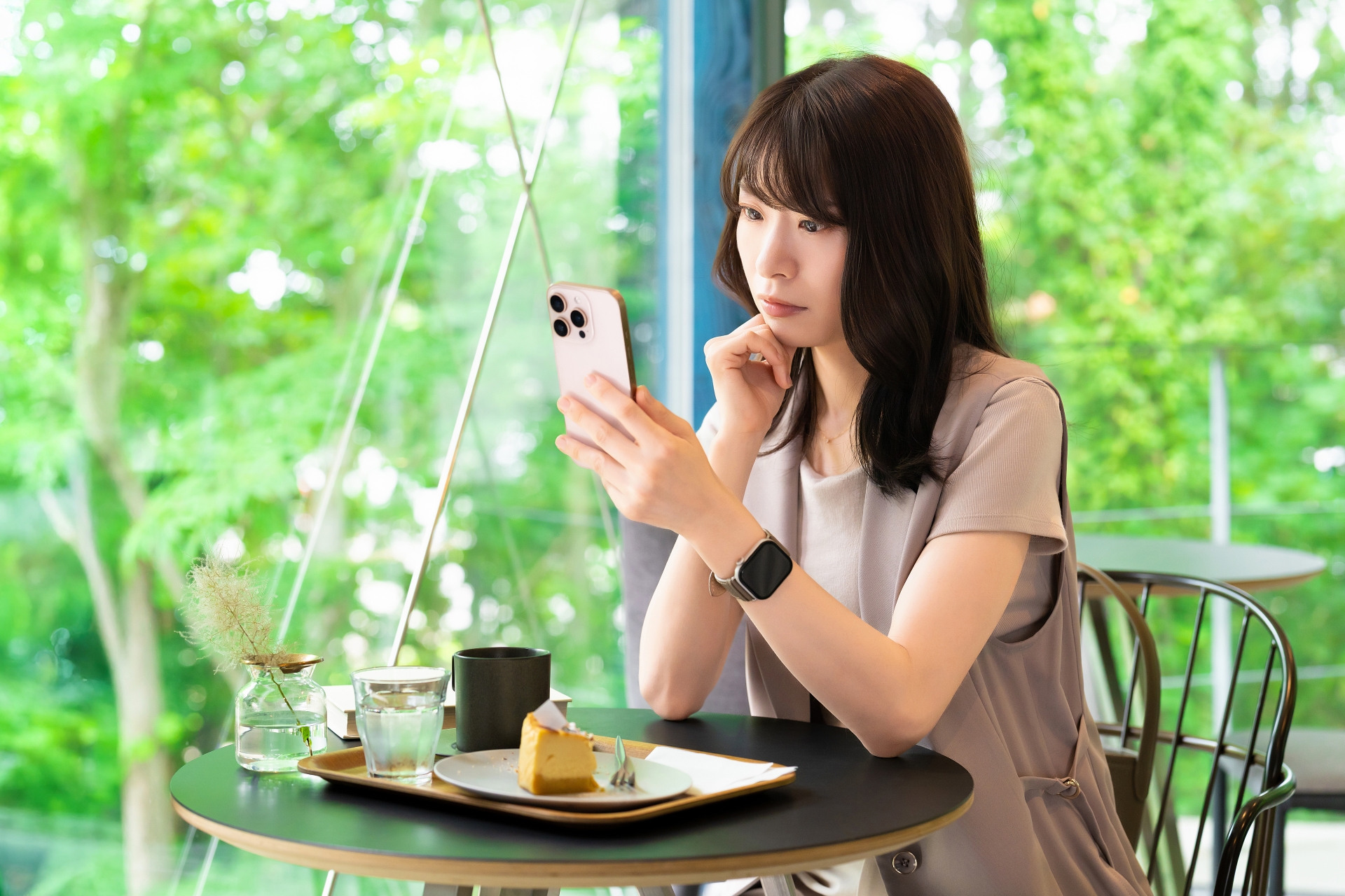 スマホを見ながら考える女性