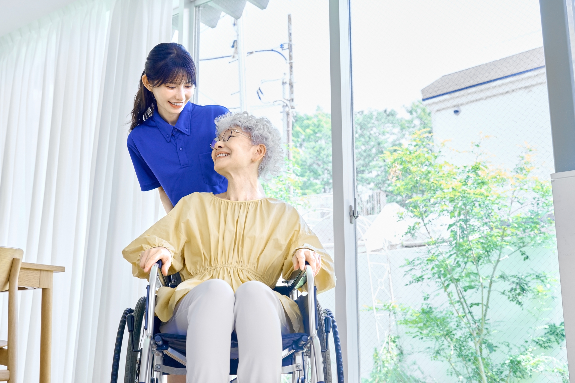 介護士を見上げる車椅子の女性