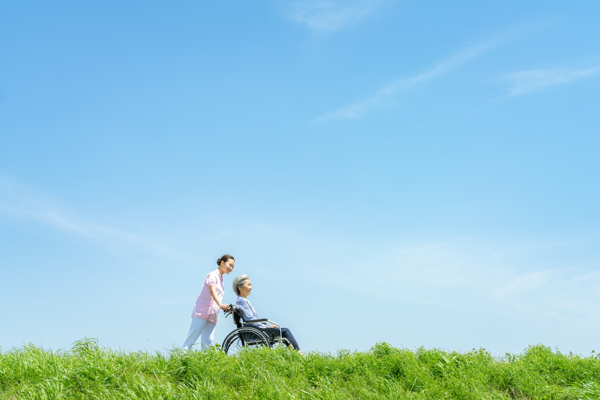 車椅子のシニアと介護士