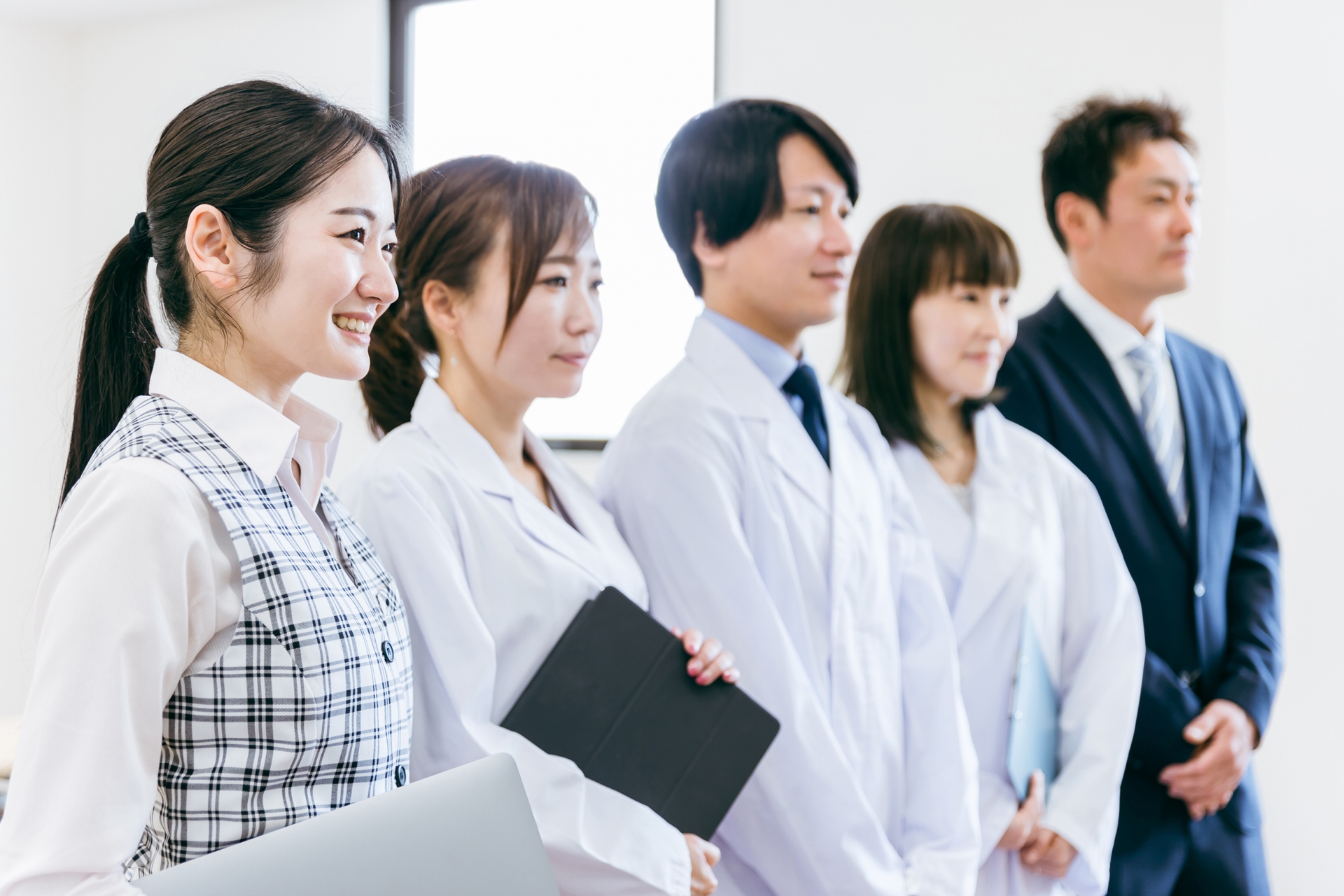 一列に並ぶ医療事務と医療従事者たち