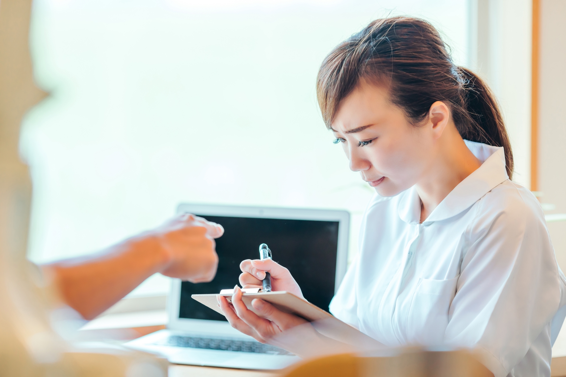 辛そうに事務をする女性