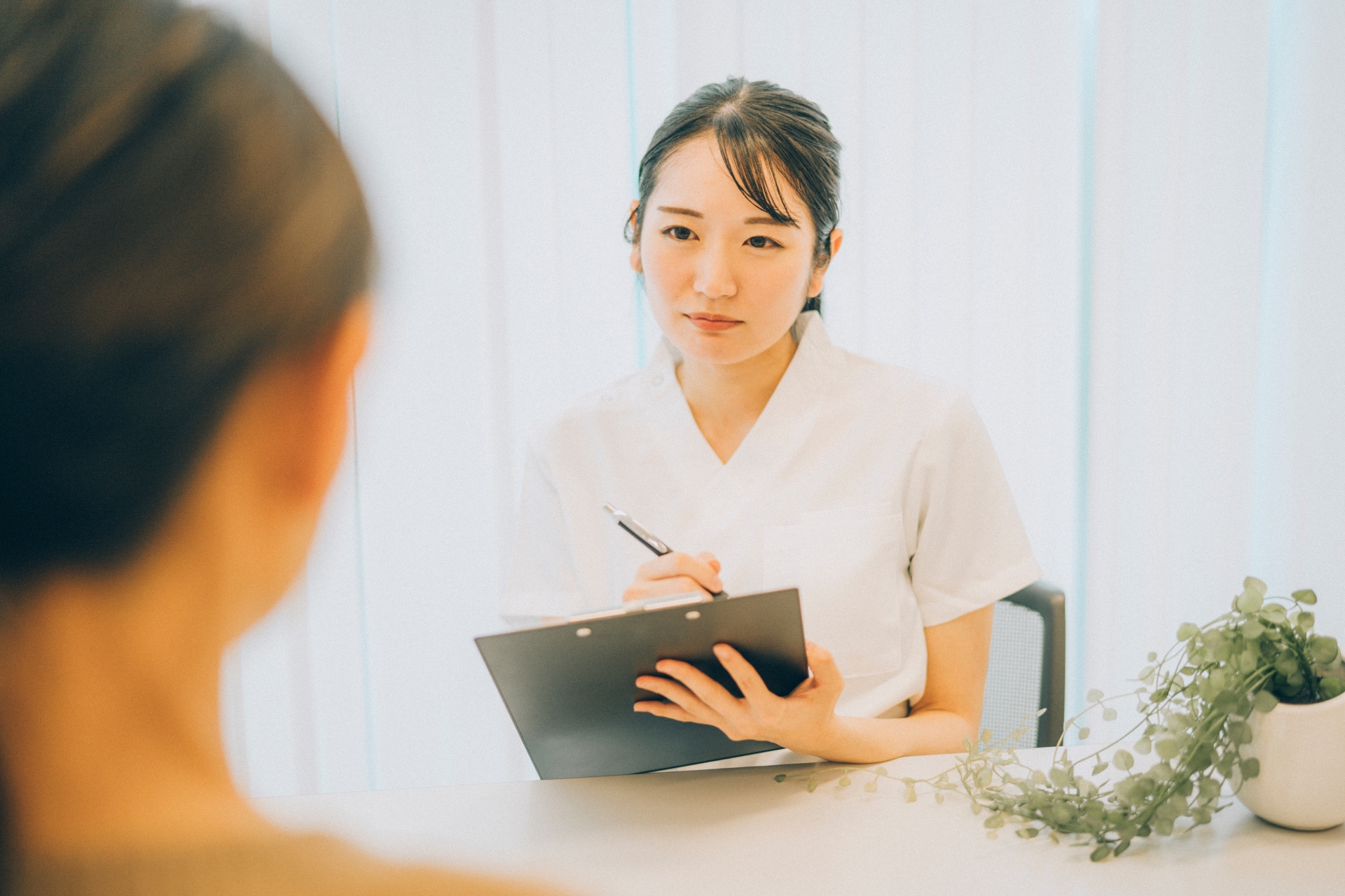 真剣に話を聞く白衣の女性