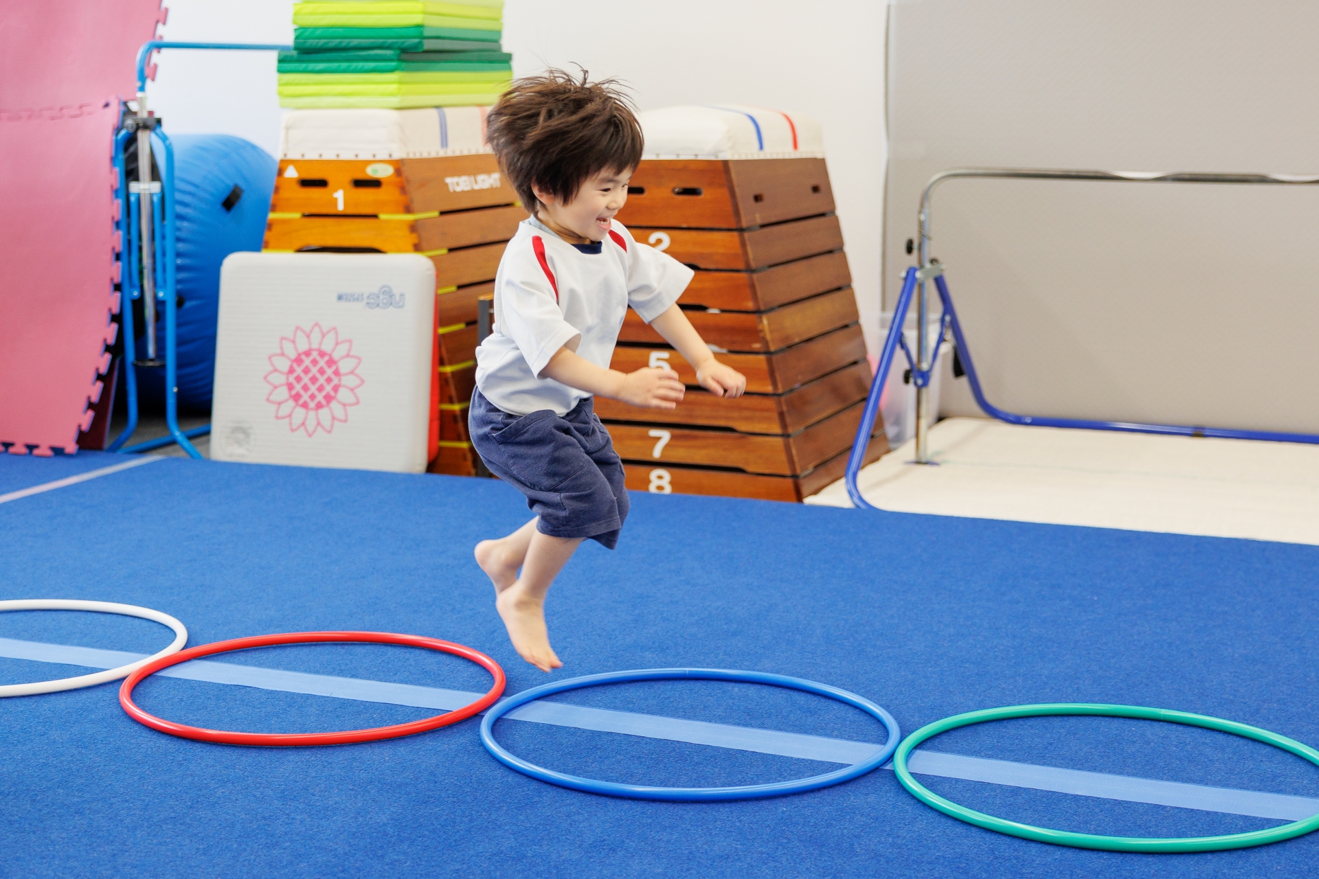 フラフープをジャンプする男の子