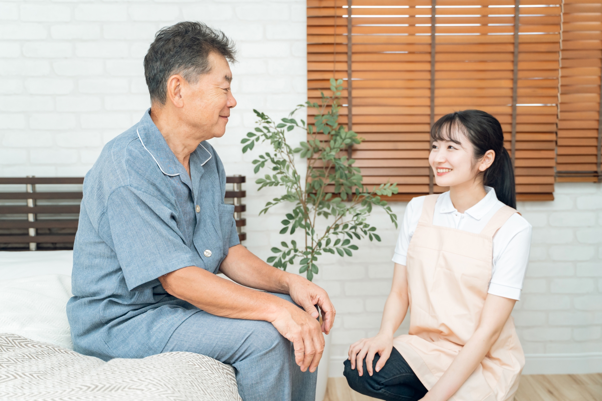 高齢者男性と話す女性スタッフ