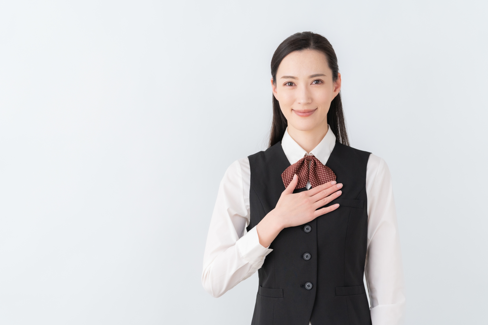 胸に手を当てる制服の女性