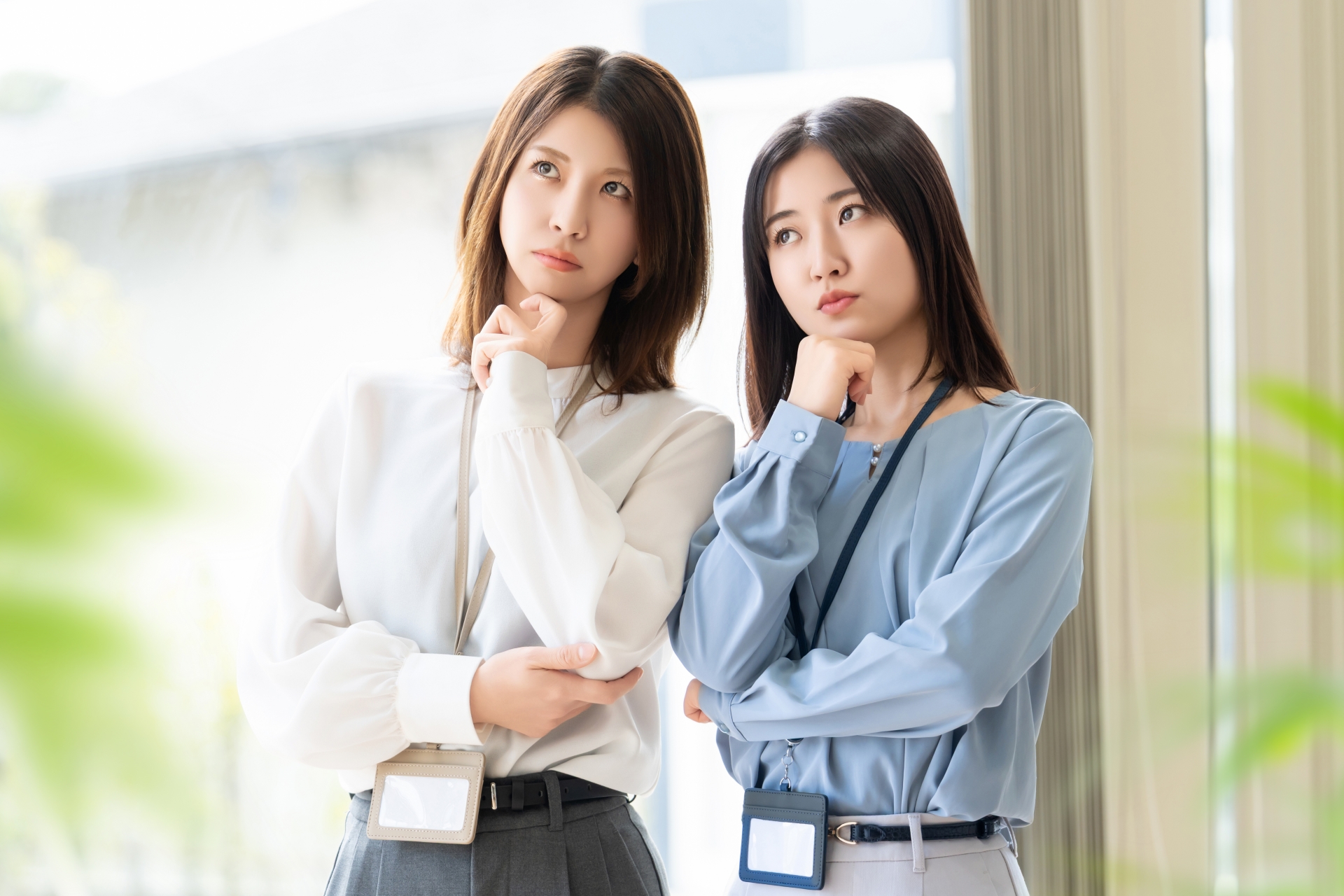 あごに手を当てて悩む2人の女性