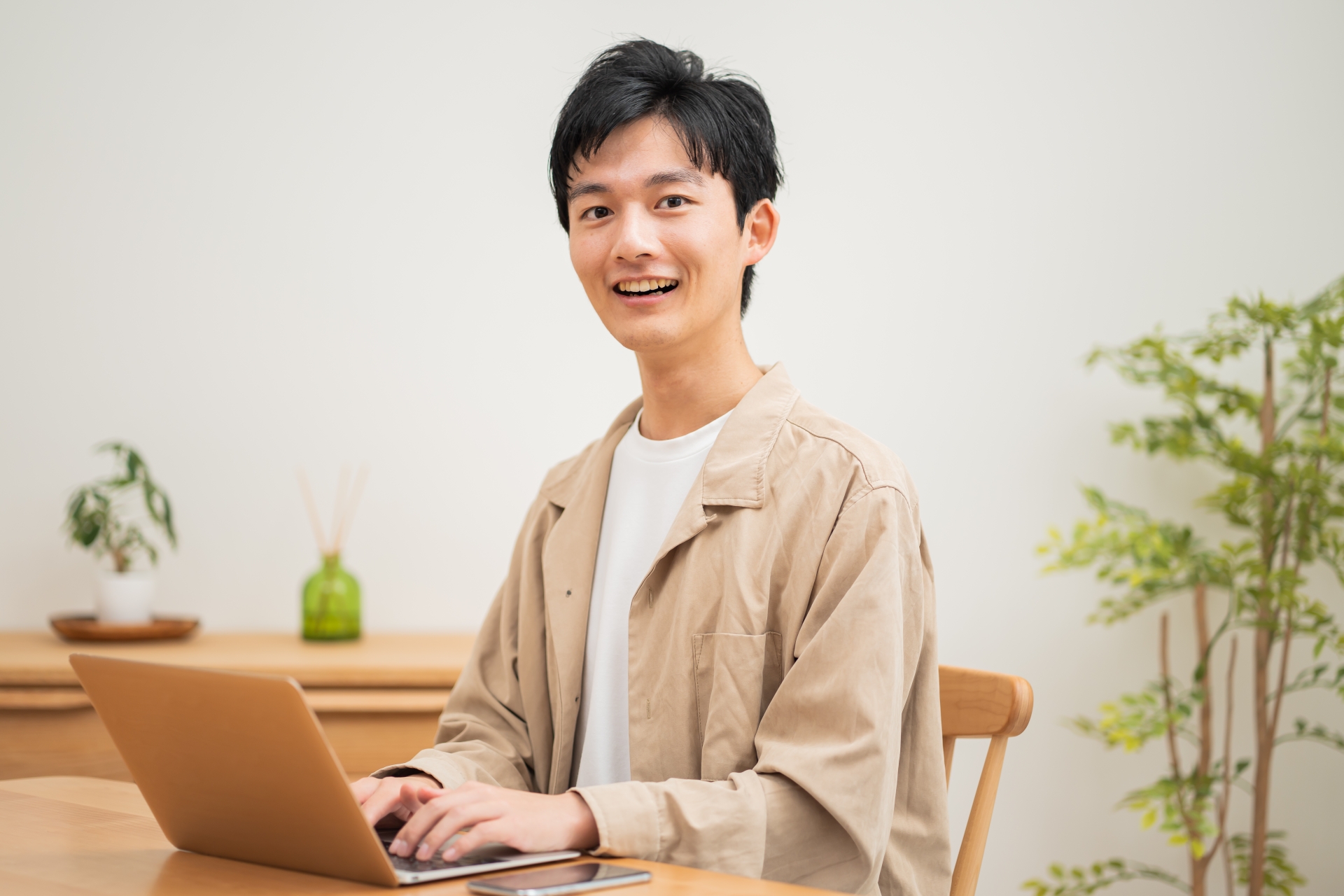 笑顔でパソコンを操作する男性