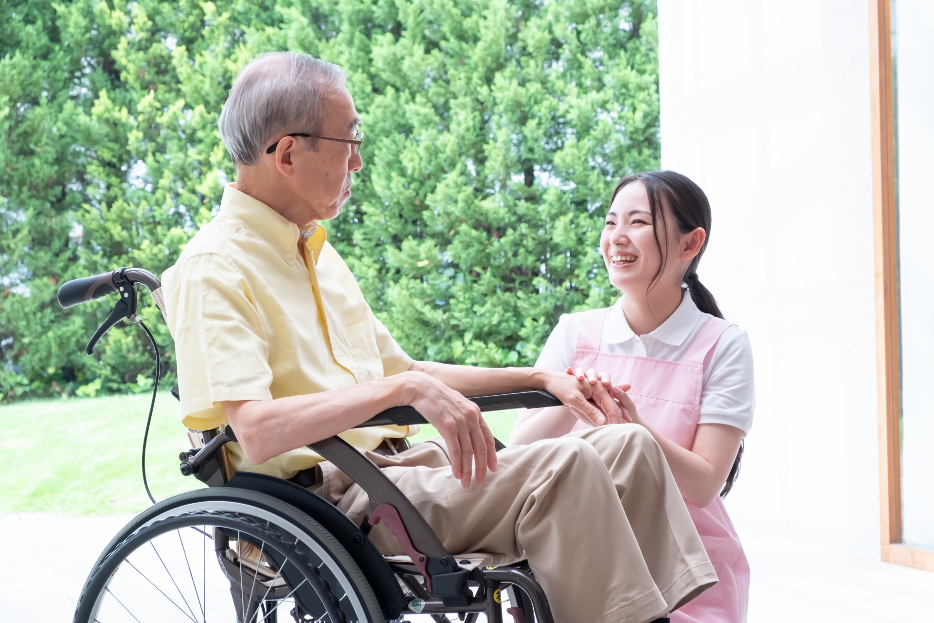 車椅子の男性と話す介護士