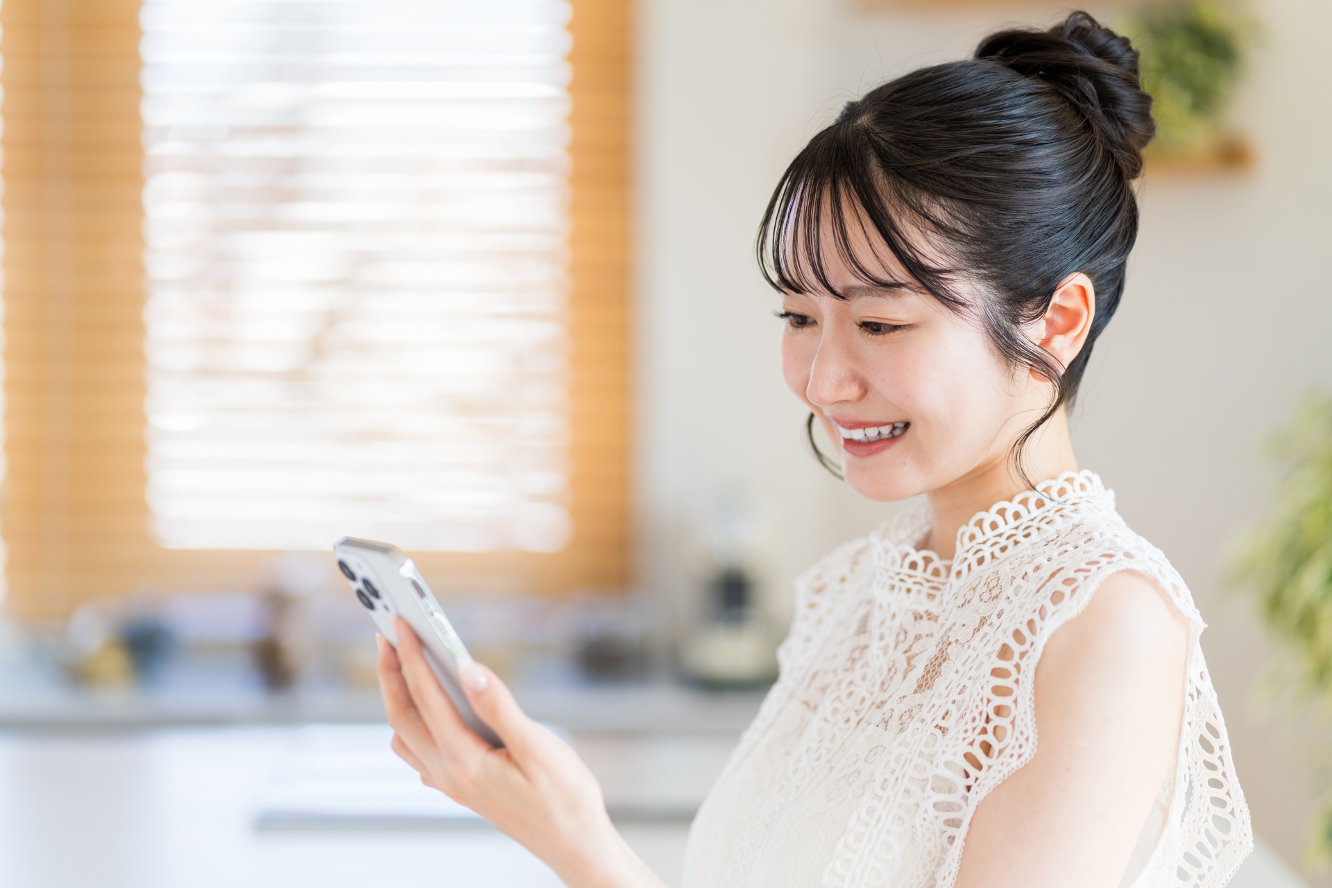 リビングでスマートフォンを操作する女性