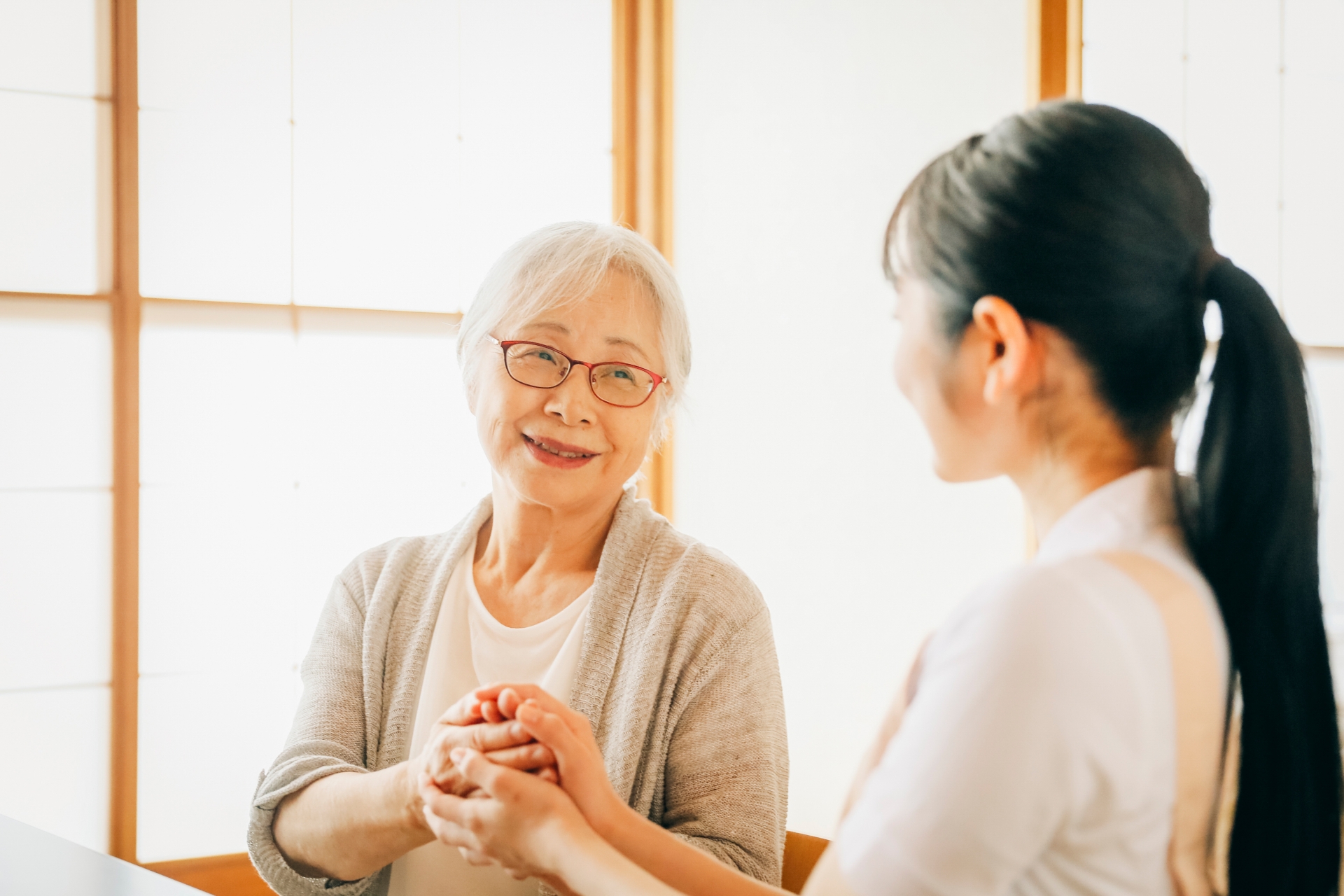 高齢者女性と話す女性スタッフ