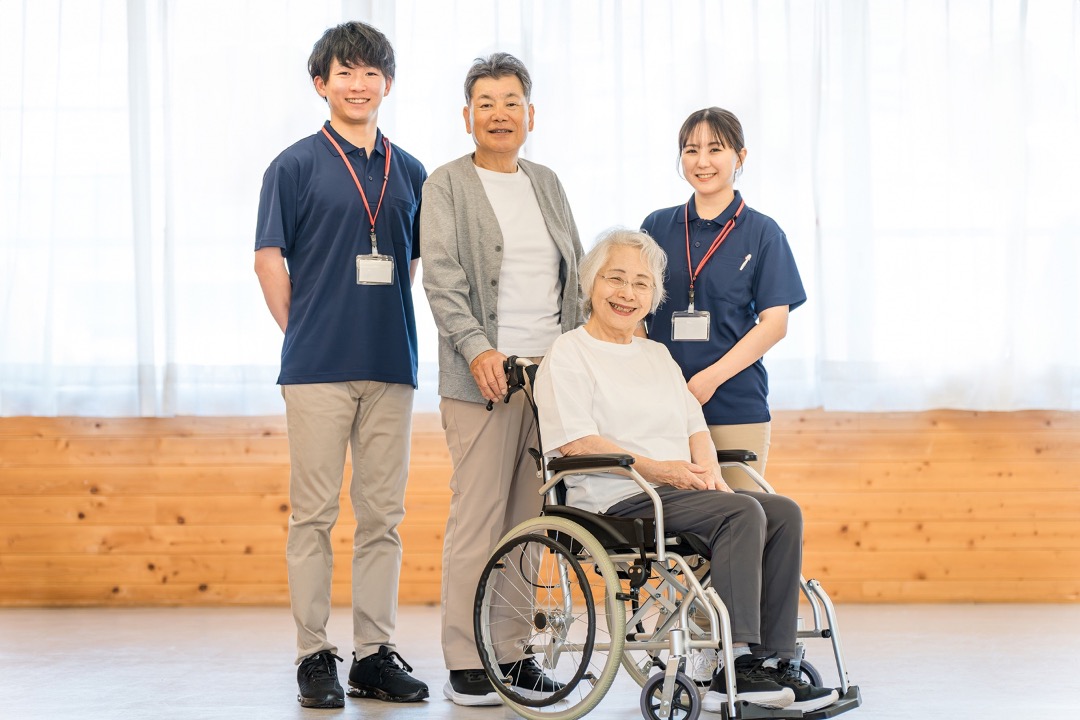 老人ホームにいるシニア夫婦と介護職員