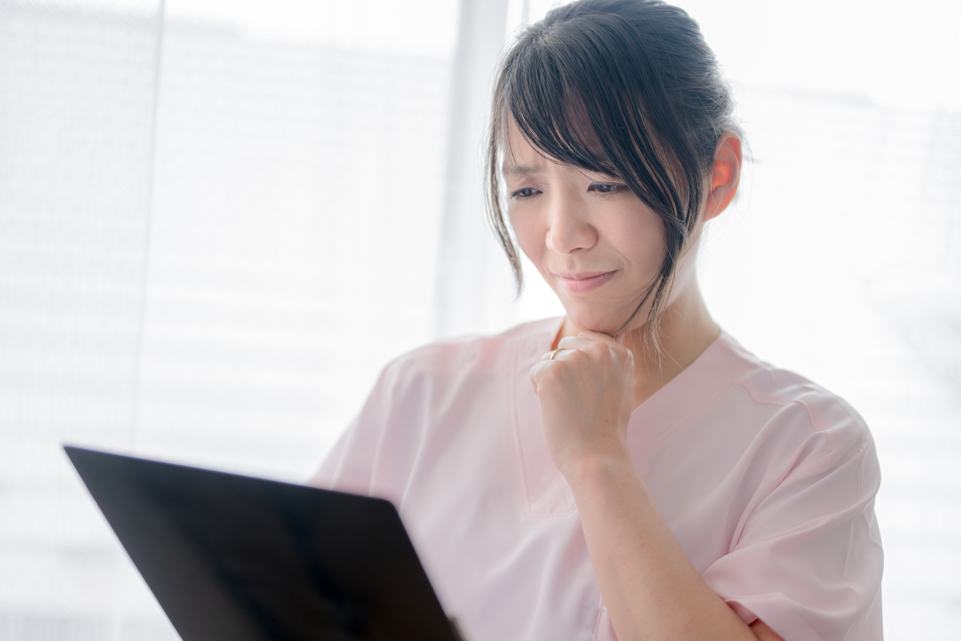 顔を歪める若い医療系女性