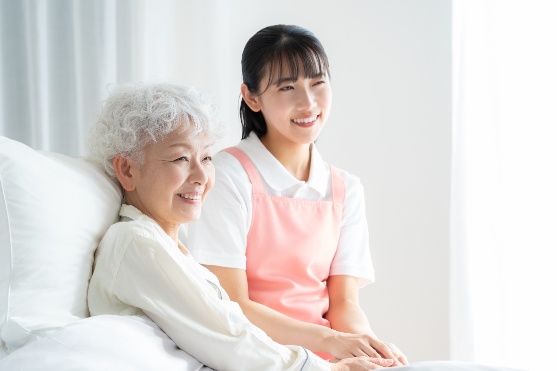 ベッドにいる利用者に寄り添う女性